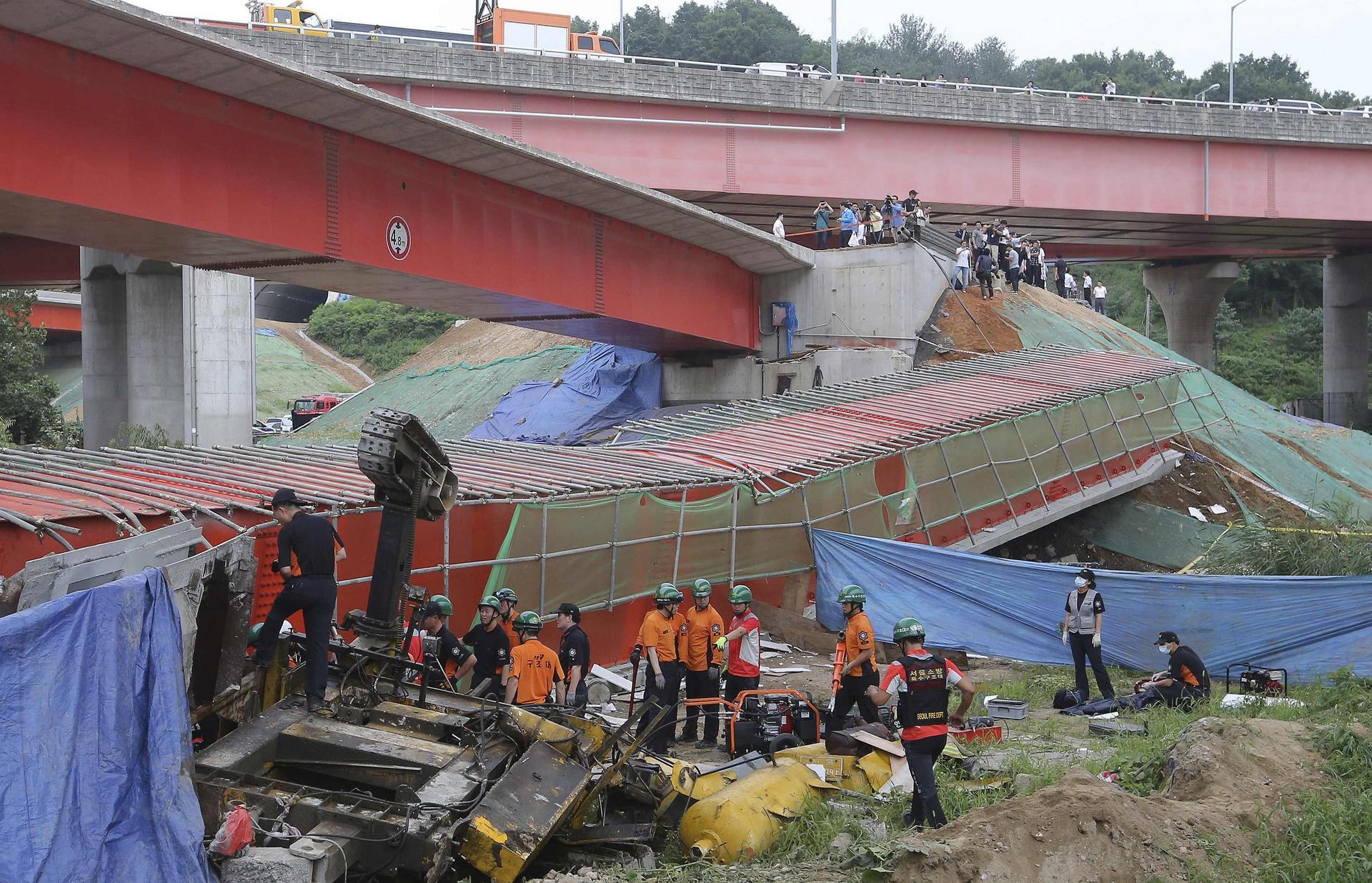 Firefighters and police carry out checks following the accident at Banghwa bridge. Two Korean-Chinese workers died.Photo: Reuters
