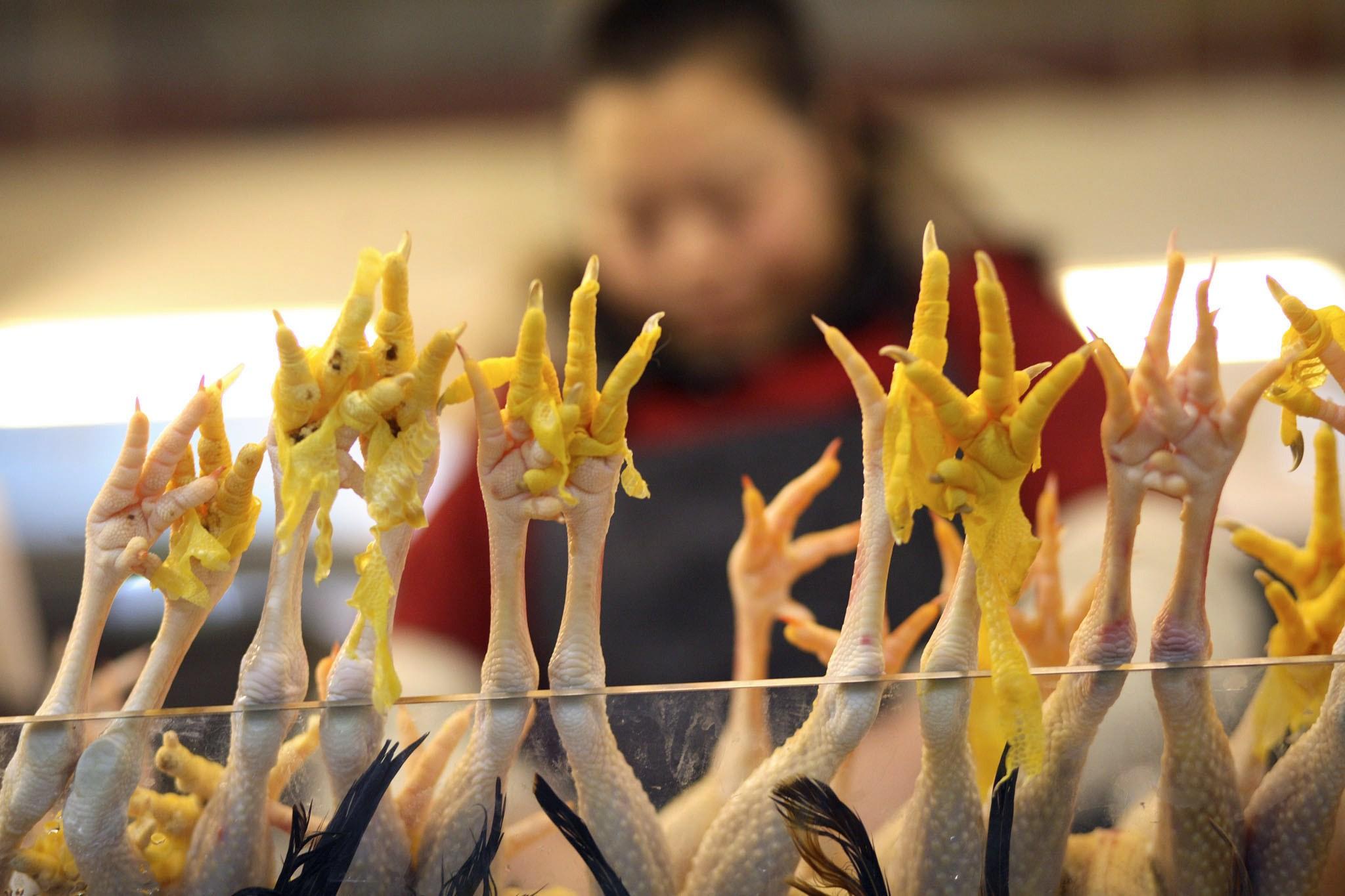 Chicken feet stick up from behind a stall glass panel at a market in Shanghai. Photo: EPA