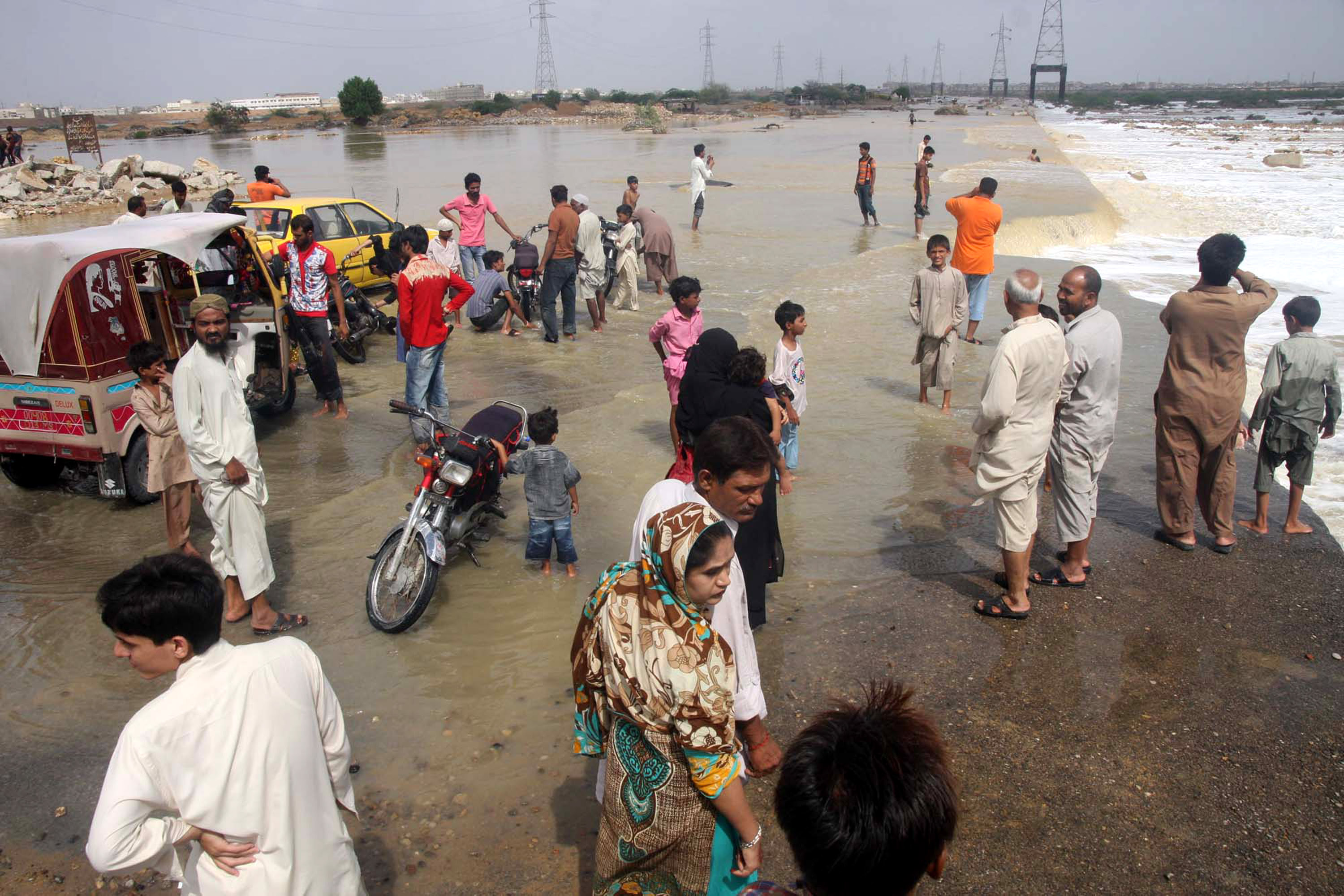 People wade through flooded road caused by heavy rains on the outskirts of Karachi. Photo: Xinhua