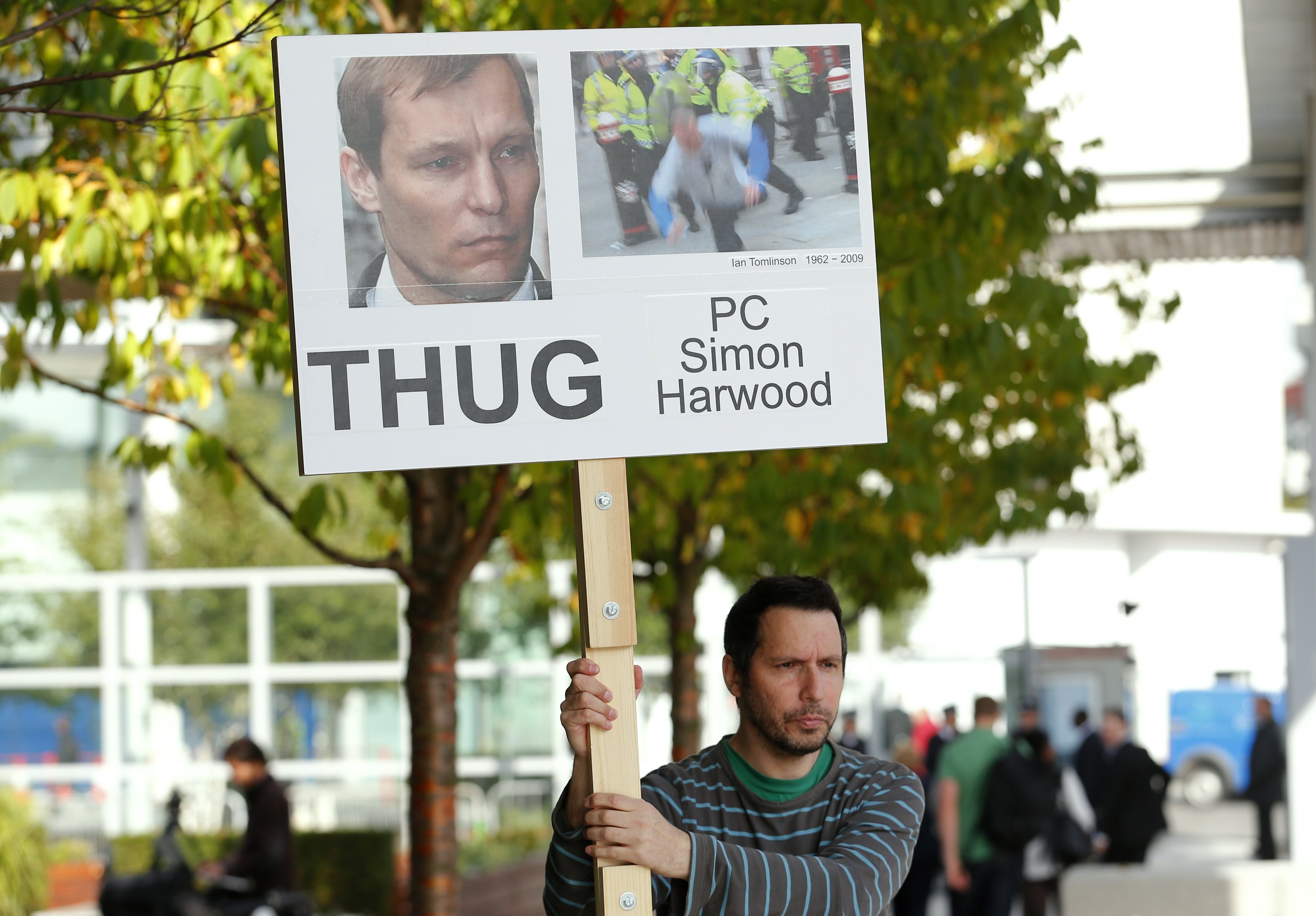 A protester holds a placard during a Metropolitan Police disciplinary hearing for police officer Simon Harwood. Photo: Reuters