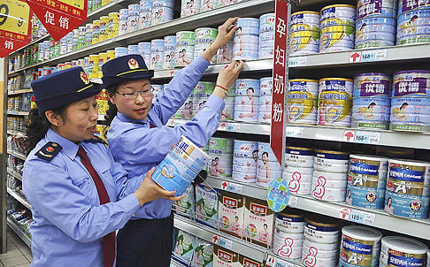 Chinese commercial law enforcement personnel inspect milk powder products at a supermarket in Lianyungang, Jiangsu province on Tuesday. Photo: Reuters