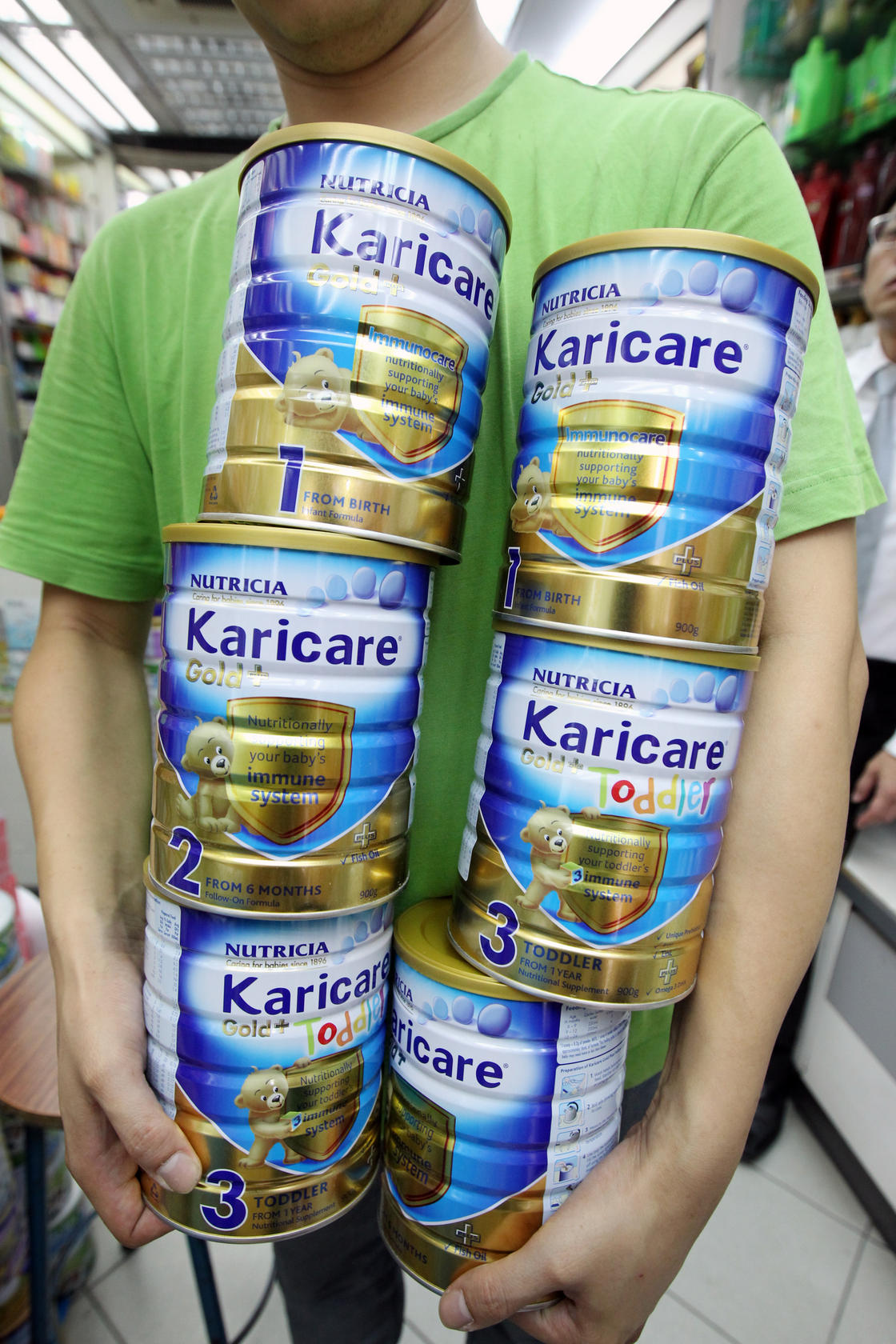 A Wan Chai pharmacy worker removes tins of Karicare infant milk formula, which a distributor recalled as a precaution. Photo: David Wong