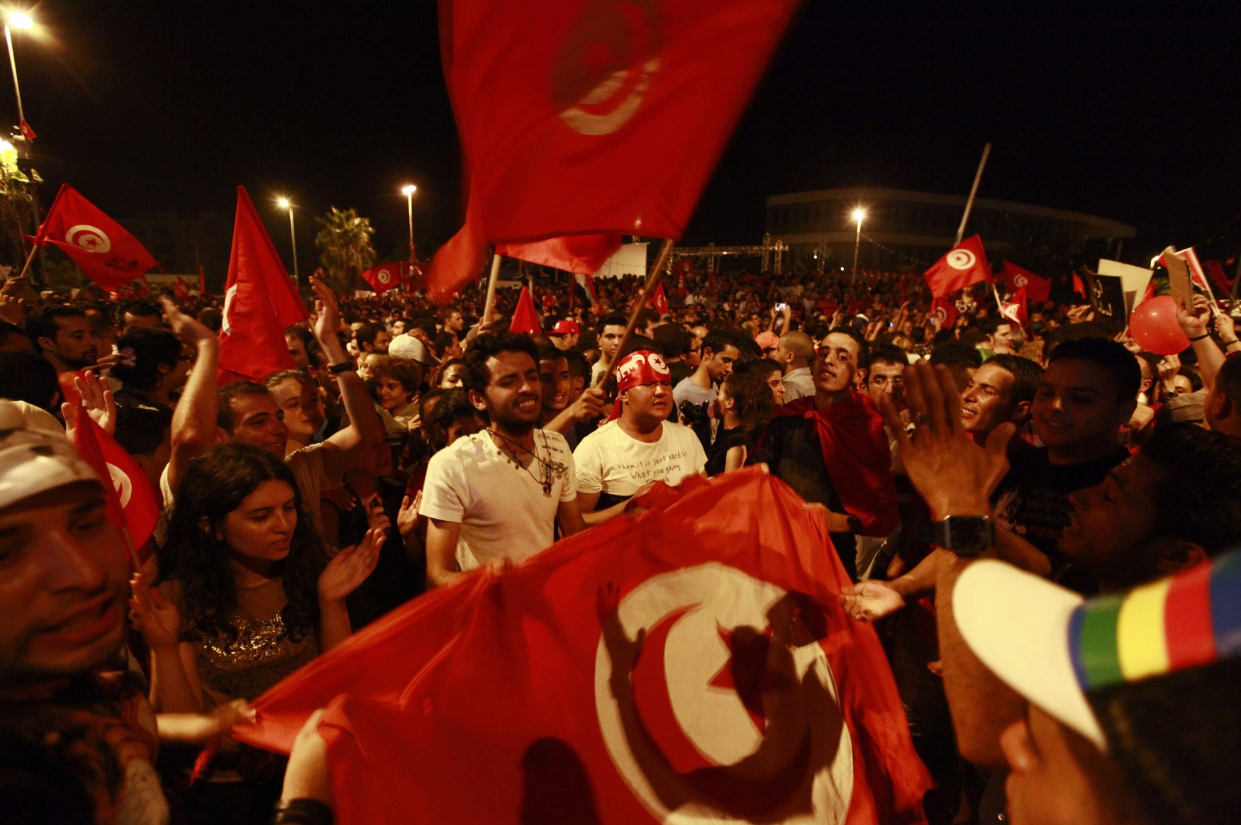 Anti-government protesters wave national flags during a demonstration in Tunis on Tuesday. Photo: AFP