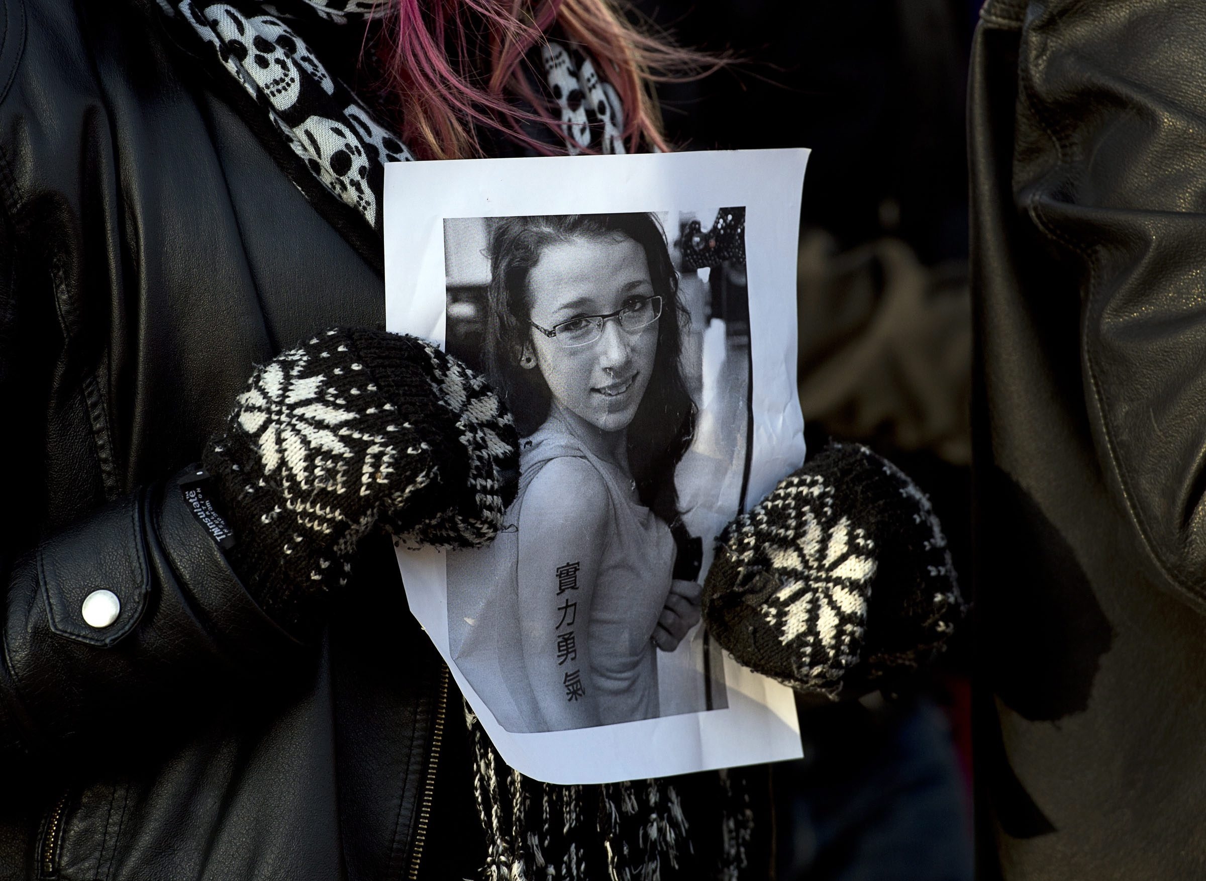 A woman holds a photo as people attend a vigil to remember Rehtaeh Parsons at Victoria Park in Halifax, Nova Scotia, Canada. Police said they have made two arrests in the case. Photo: AP
