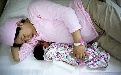 Chinese new mother Qi Wenjuan breastfeeds her one-day-old son at Tiantan Hospital’s maternity ward in Beijing, China. Photo: AP