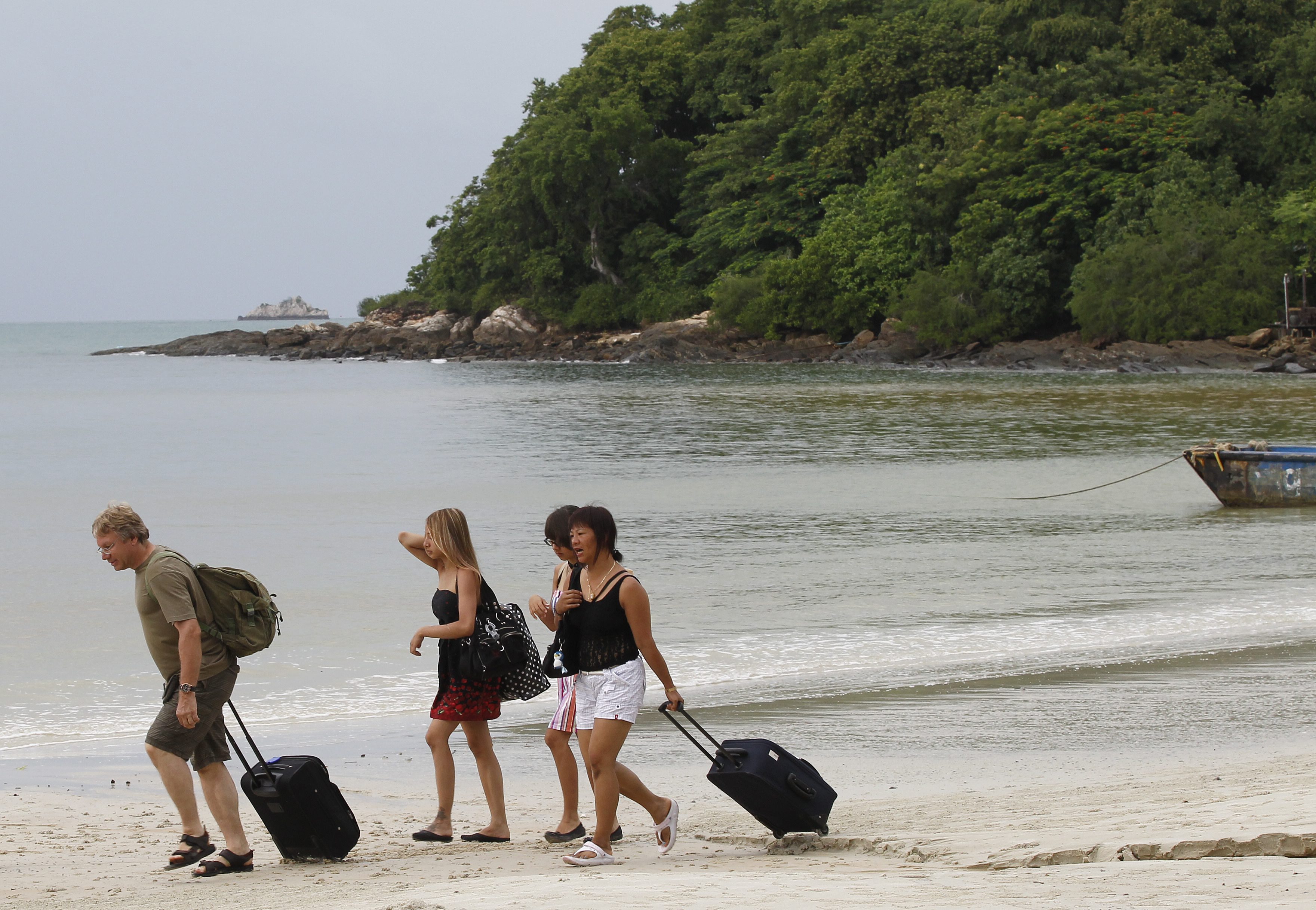 Tourists walk along a beach in Thailand. Photo: EPA