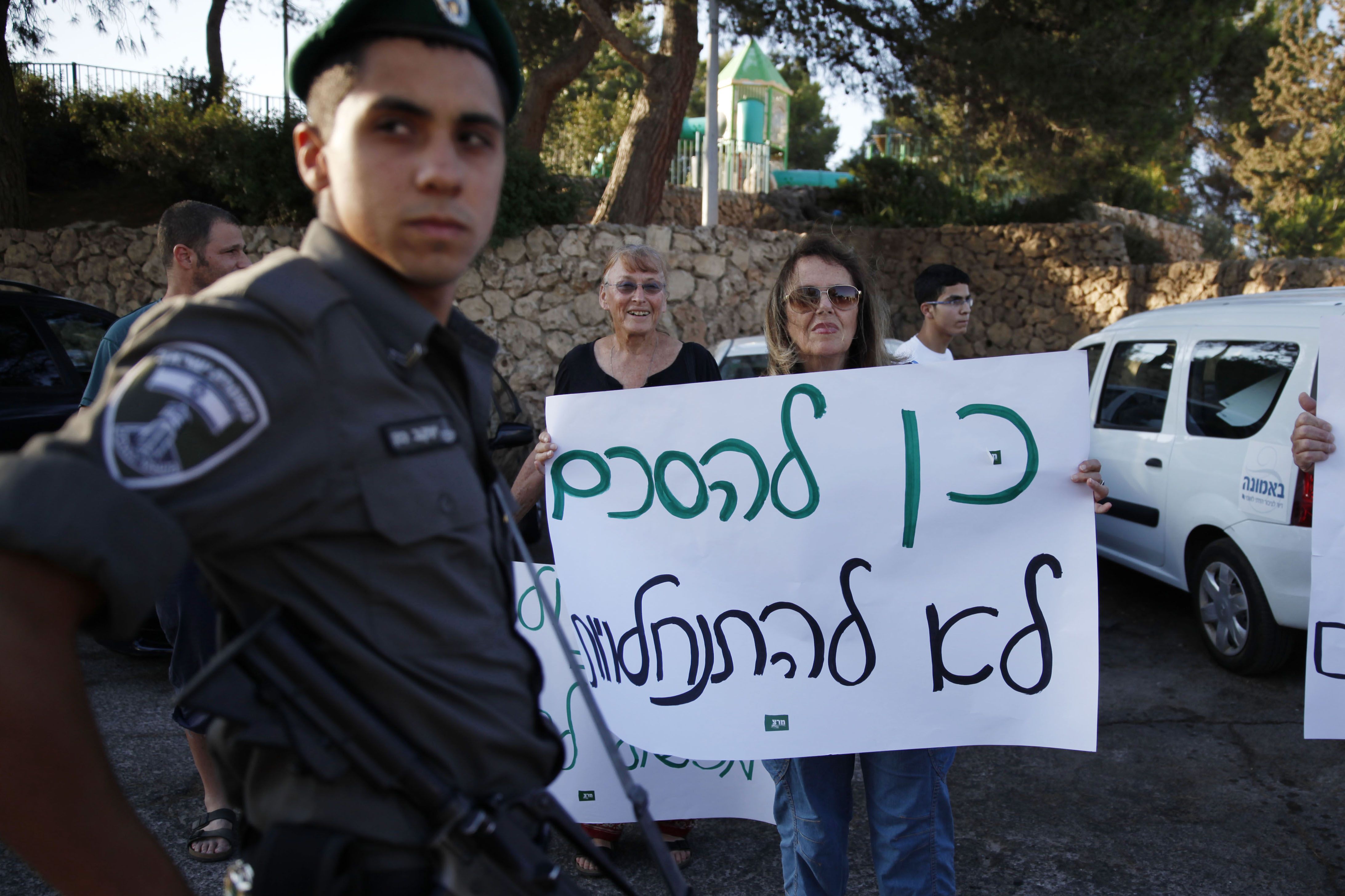 A border guard keeps watch as Israeli left-wing activists protest. Photo: AFP