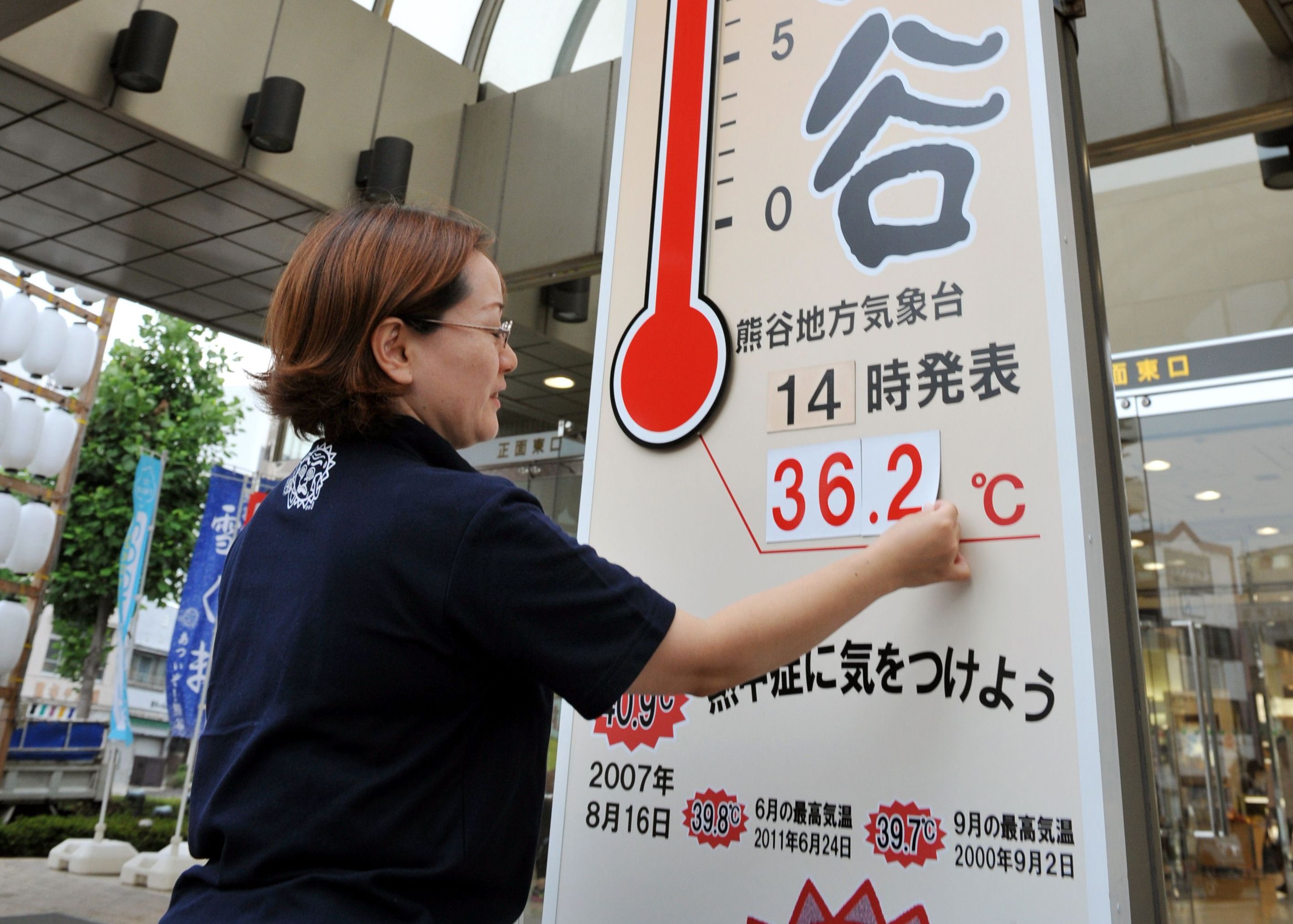 A worker at a department store puts up numbers representing the temperature in Kumagaya, Saitama prefecture. Photo: AFP