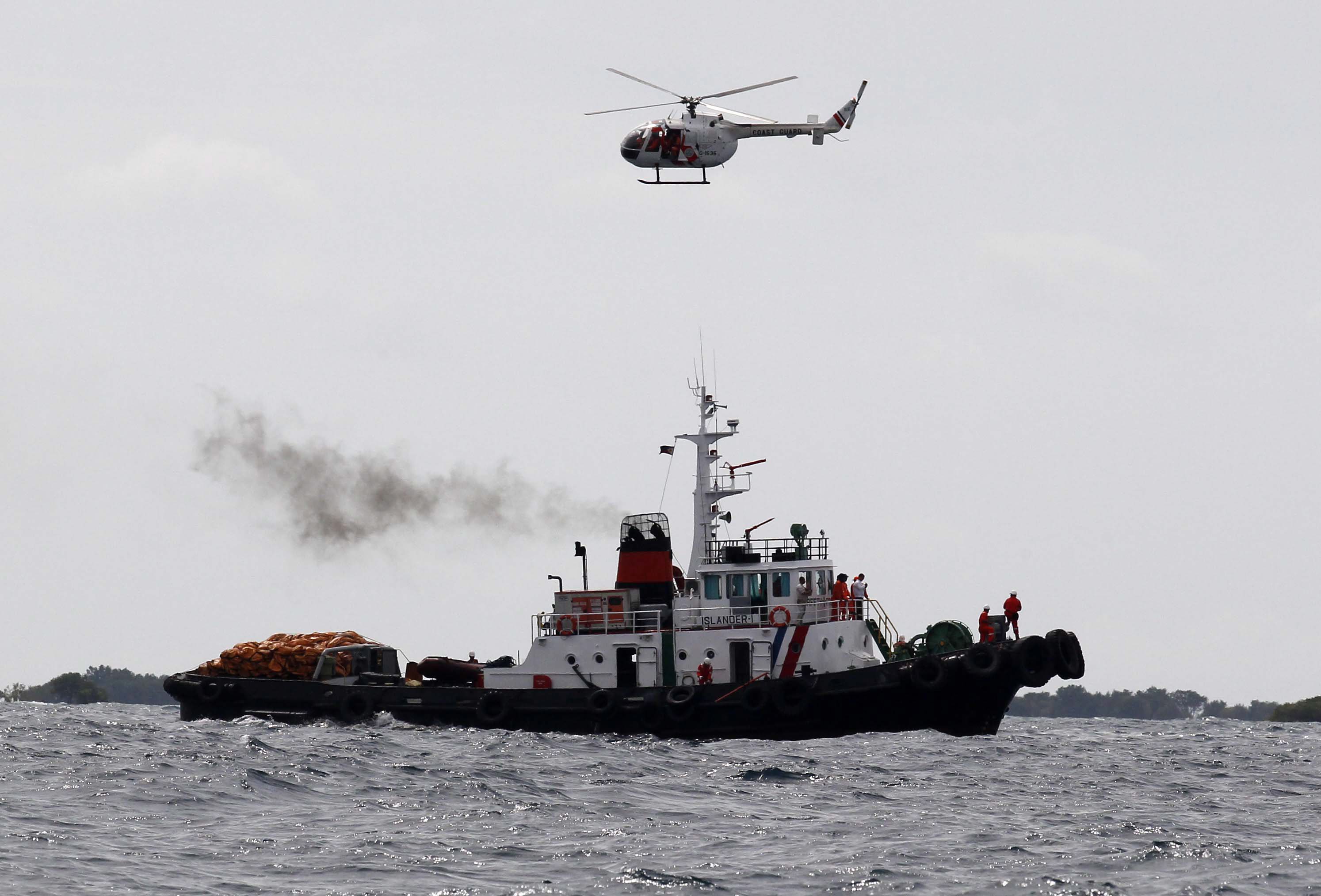A Philippine Coast Guard rescue helicopter hovers over a search and rescue vessel around the site where the St Thomas Aquinas sank. Photo: EPA