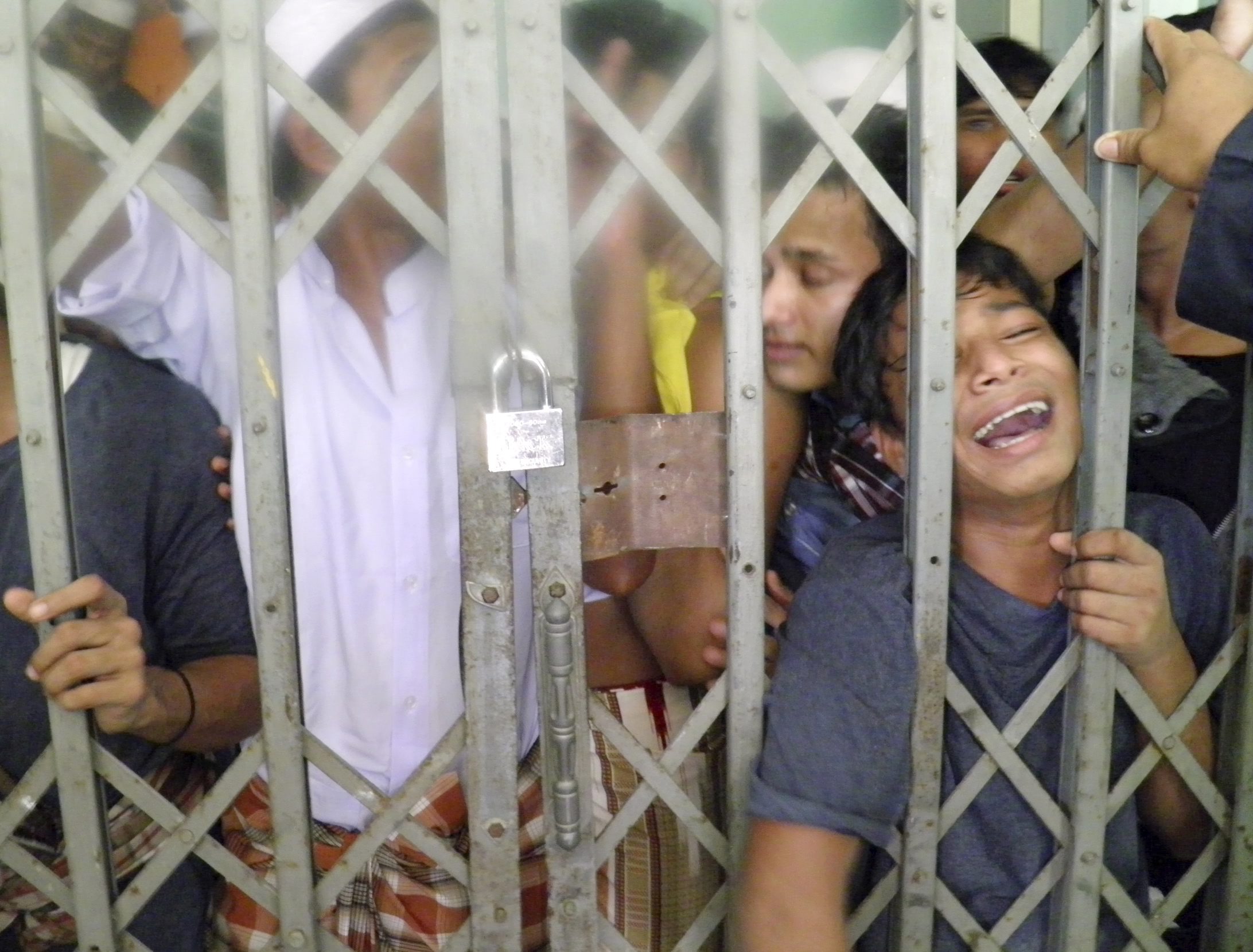 Muslim Rohingya refugees from Myanmar gather behind bars of a locked room at a detention centre in Phang Nga province, southern Thailand. Photo: EPA