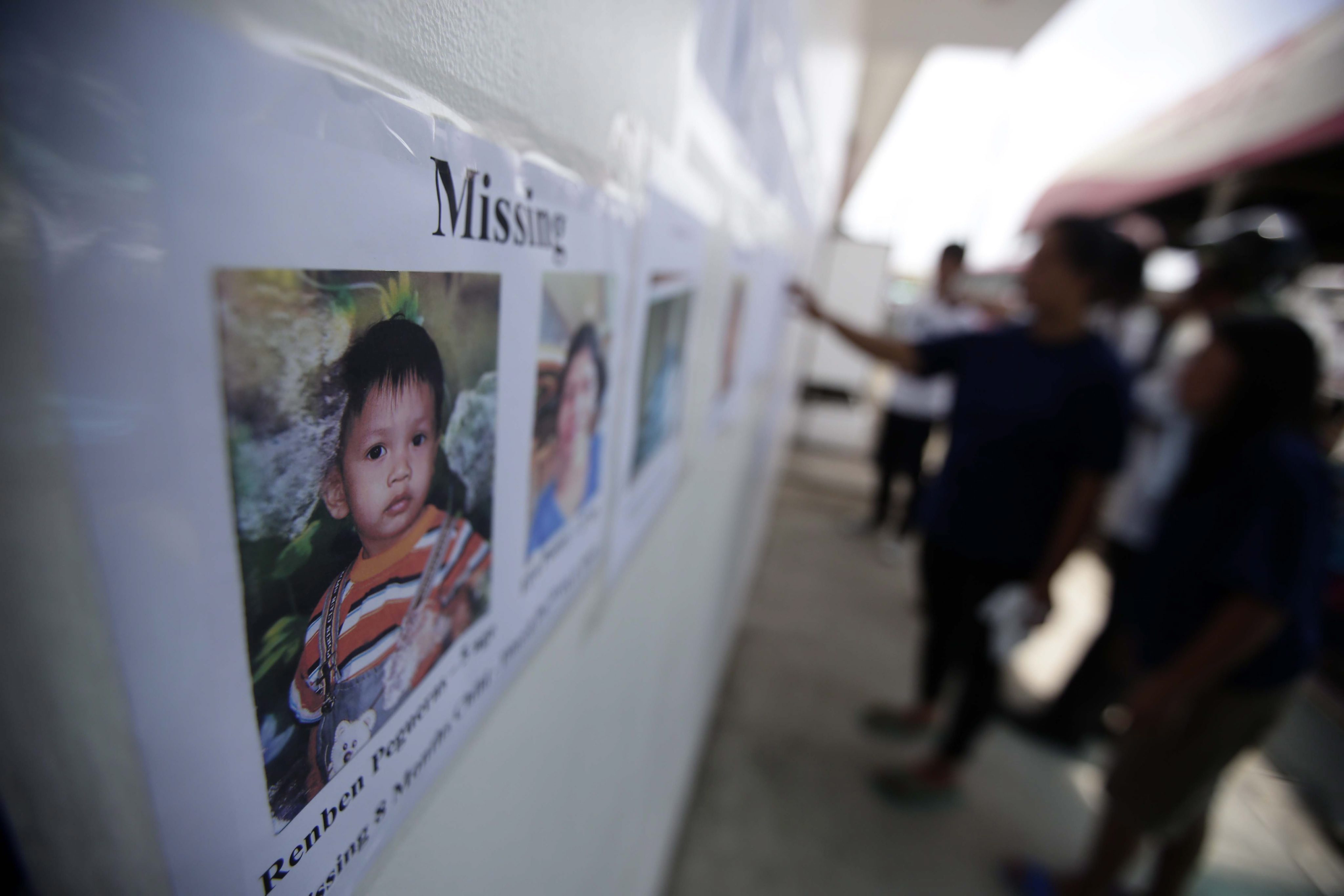 Portraits of missing passengers are posted outside the shipping terminal office in Cebu. Photo: EPA