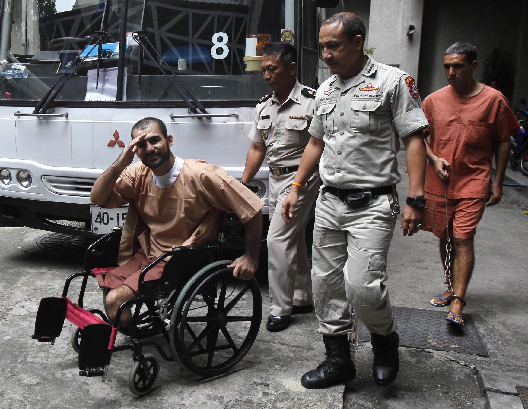 Thai prison officers escort Iranian Saeid Moradi, 29, in wheelchair, and Mohammad Khazaei, 43, as they leave the Bangkok South Criminal Court on Thursday.
