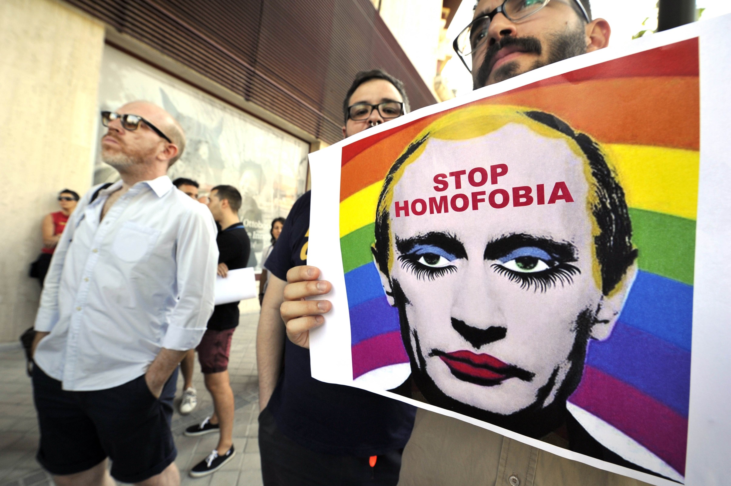 A  demonstrator holds a poster depicting Russian President Vladimir Putin with make-up as he protests against homophobia in front of the Russian Embassy in Madrid. Photo: AFP
