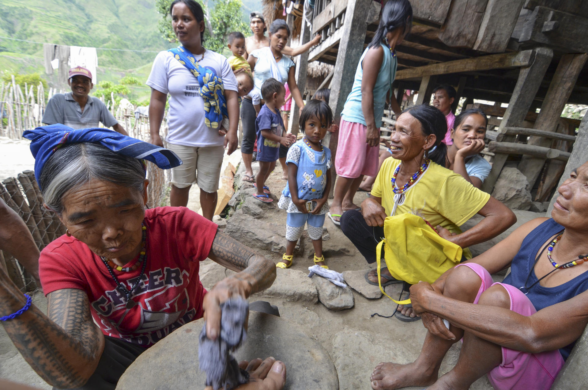 Whang Od is surrounded by villagers in Buscalan as she goes to work on Aya Lowe's foot. Photos: Aya Lowe; Robert Ditcham; Corbis