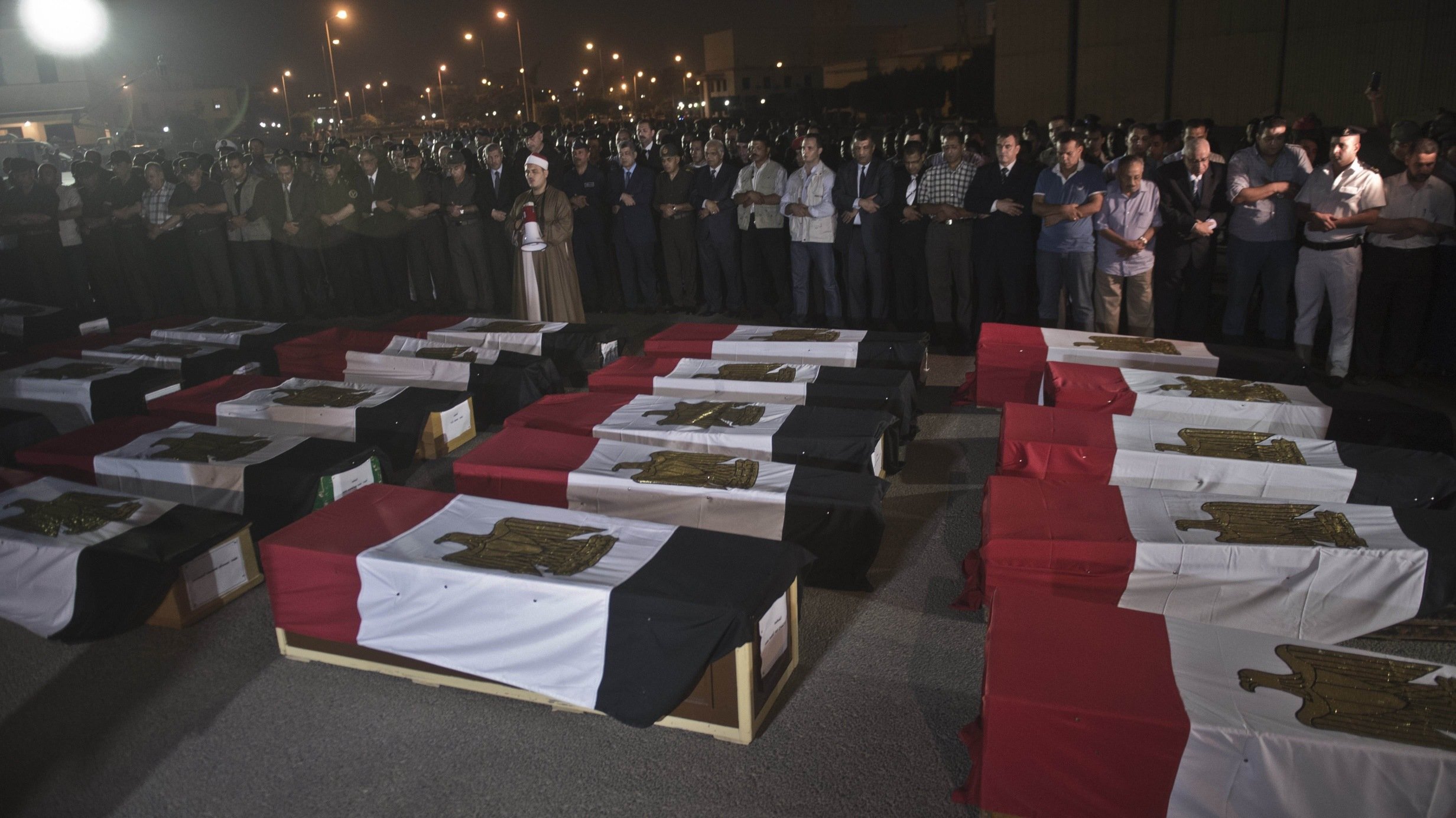 Egyptian army and security officers pray over coffins covered with the national flags at Almaza military Airbase in Cairo. There is also growing concern in Egypt about deaths occurring in police custody. Photo: AFP