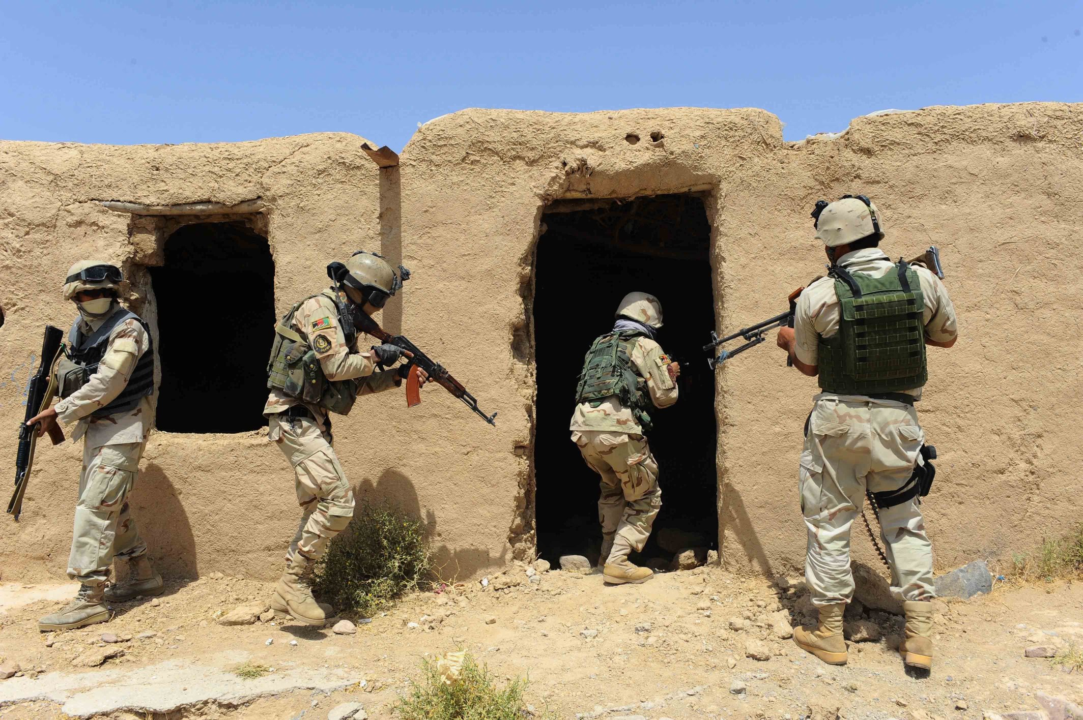 Afghan security forces search a building following an insurgent attack. Taliban insurgents killed 15 police on the main highway in western Afghanistan. Photo: AFP
