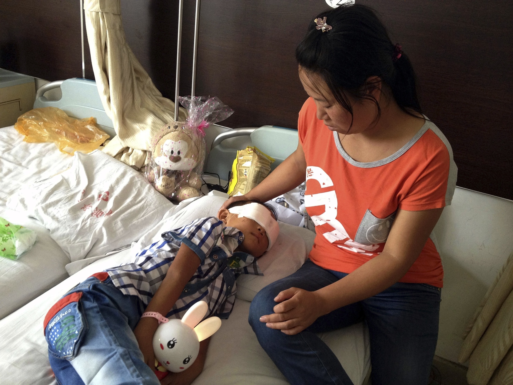 Guo Bin recuperates near his mother from an attack in the rural area of Linfen city that left him blind in a hospital in Taiyuan in northwest China's Shanxi province. Photo:AP