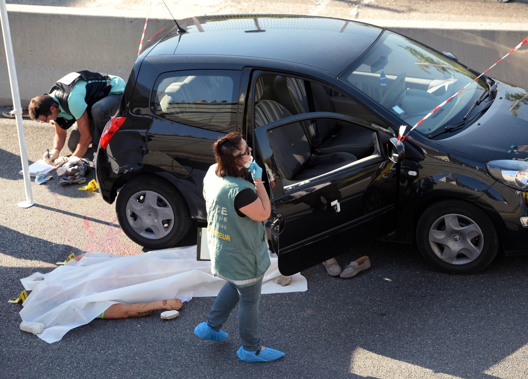 Forensic experts inspect the crime scene where Adrien Anigo, son of the Olympique de Marseille football team manager Jose Anigo, was shot dead by two men on a motorbike as he drove his car in Marseille, southern France. Photo: AFP
