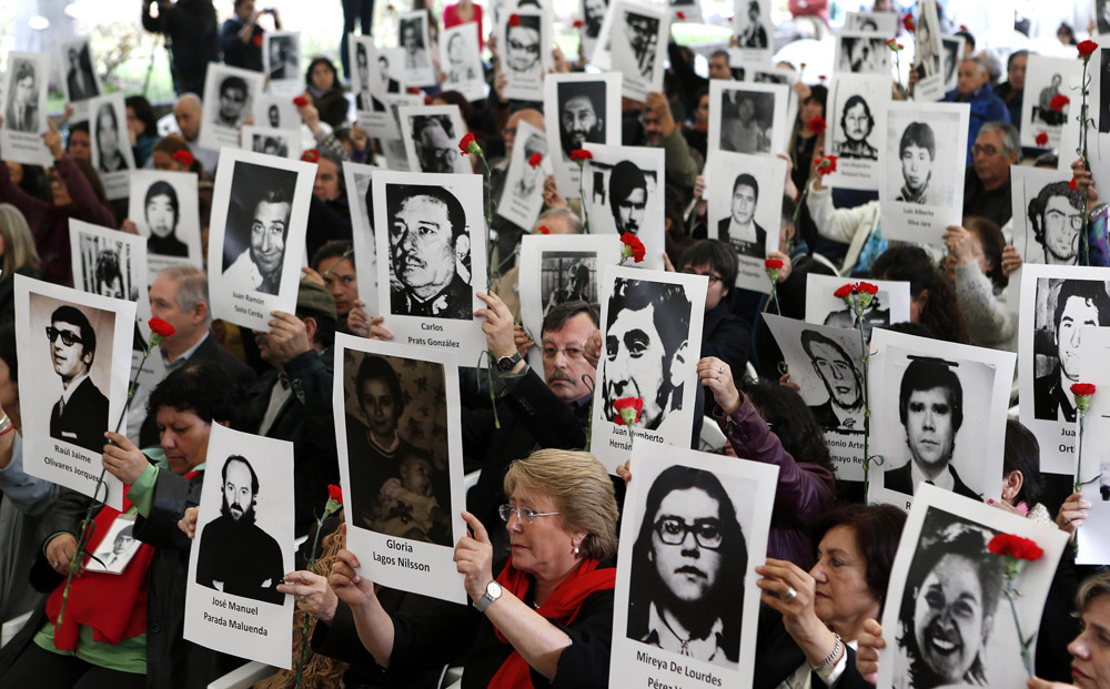 Chileans hold up pictures of victims of human rights abuse during a ceremony commemorating 40 years of the military coup at the Parque Por La Paz in Santiago. Photo: Reuters