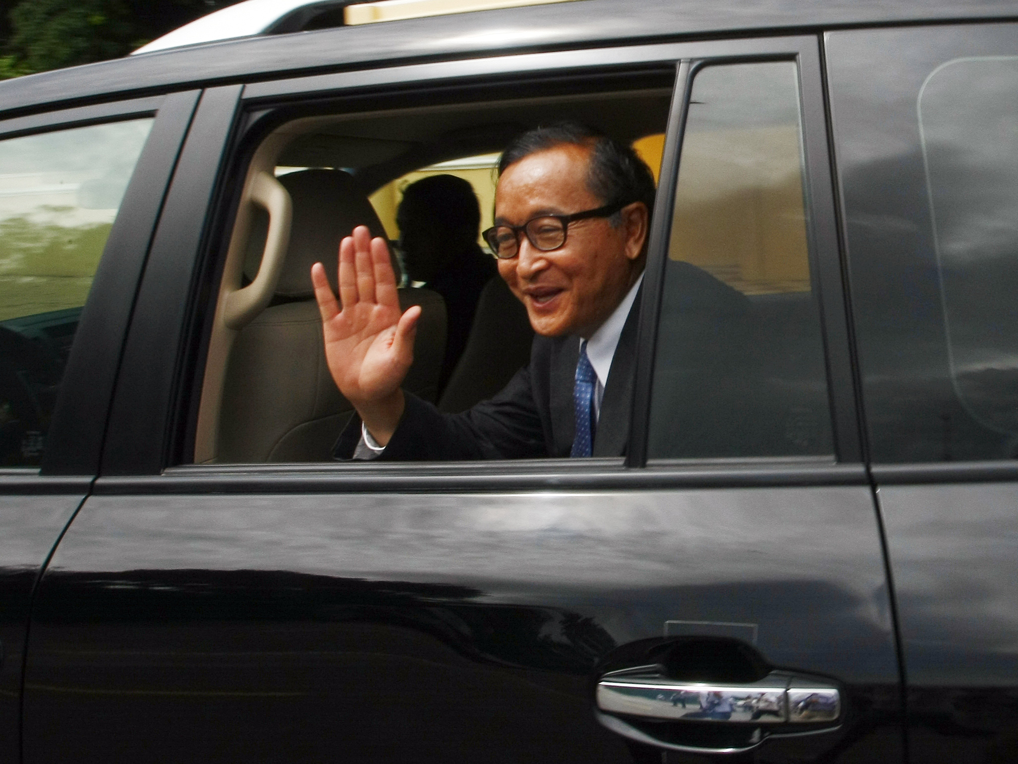 Cambodia's opposition leader Sam Rainsy waves from his car after a meeting in Phnom Penh. Photo: AP