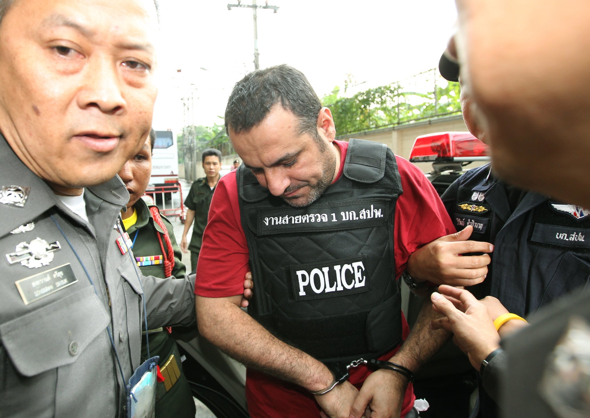 Swedish-Lebanese man Attis Hussein (C) is escorted by Thai police officers as he arrives at the criminal court in Bangkok, Thailand. Photo: EPA