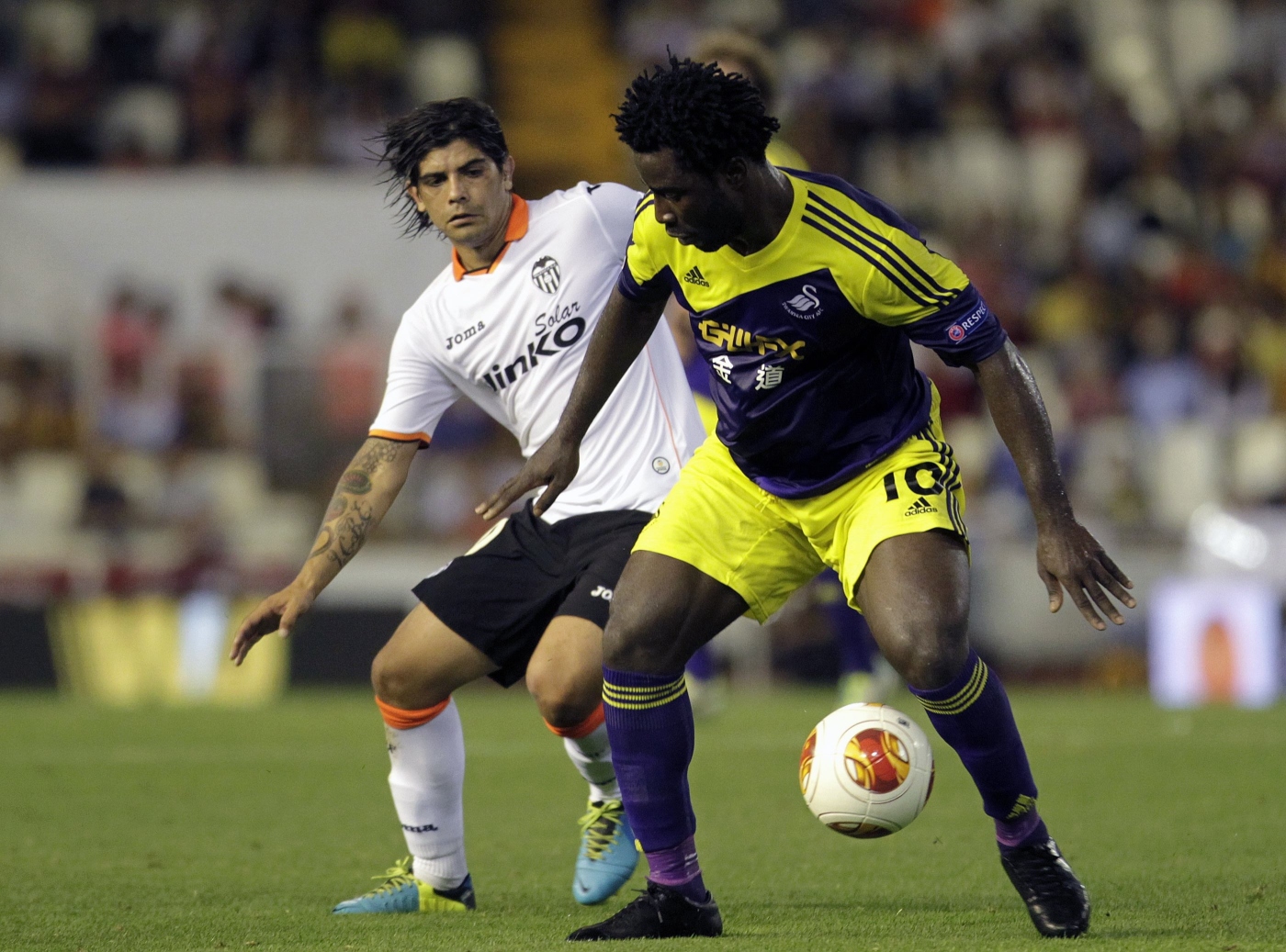 Swansea City's Wilfried Bony (R) and Valencia's Ever Banega fight for the ball during their Europa League soccer match at the Mestalla stadium in Valencia. Photo: Reuters
