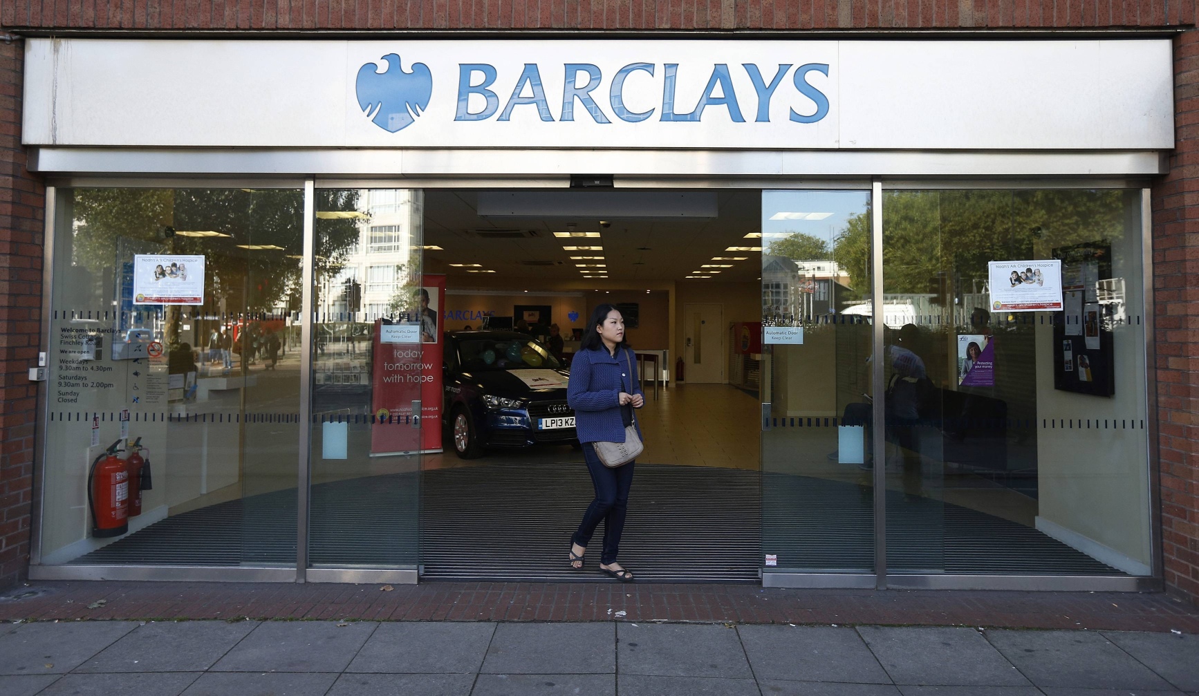 A woman leaves the Swiss Cottage branch of Barclays in London. Eight men have been arrested over the alleged theft of US$2.1 million by taking control of a Barclays branch computer system. Photo: Reuters