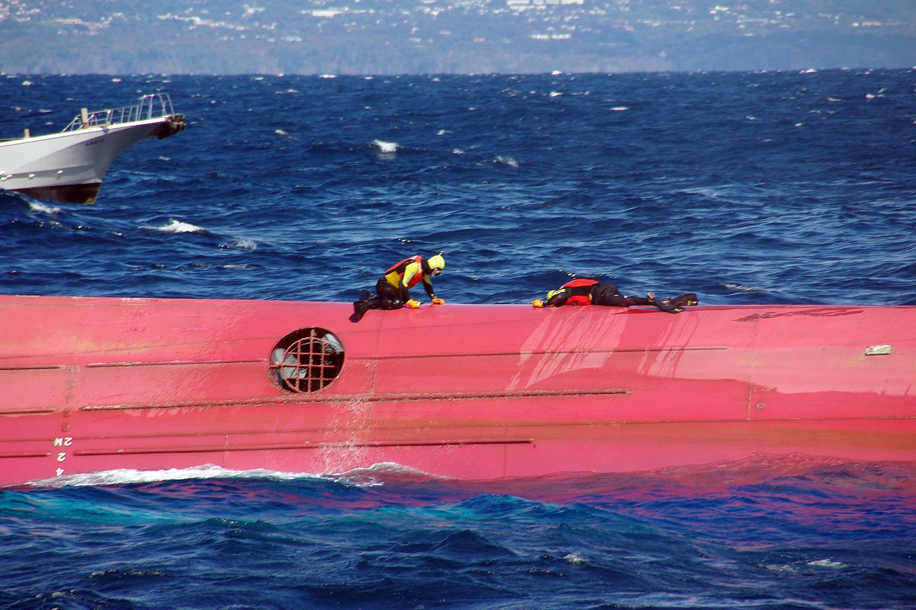 Rescuers on on the capsized Eifuku Maru No 18 after it crashed near Izuoshima island. Photo: EPA