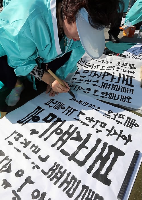 A South Korean woman participates in a calligraphy contest to observe Hangul Day. Photo: Screenshot via Yonhap News.
