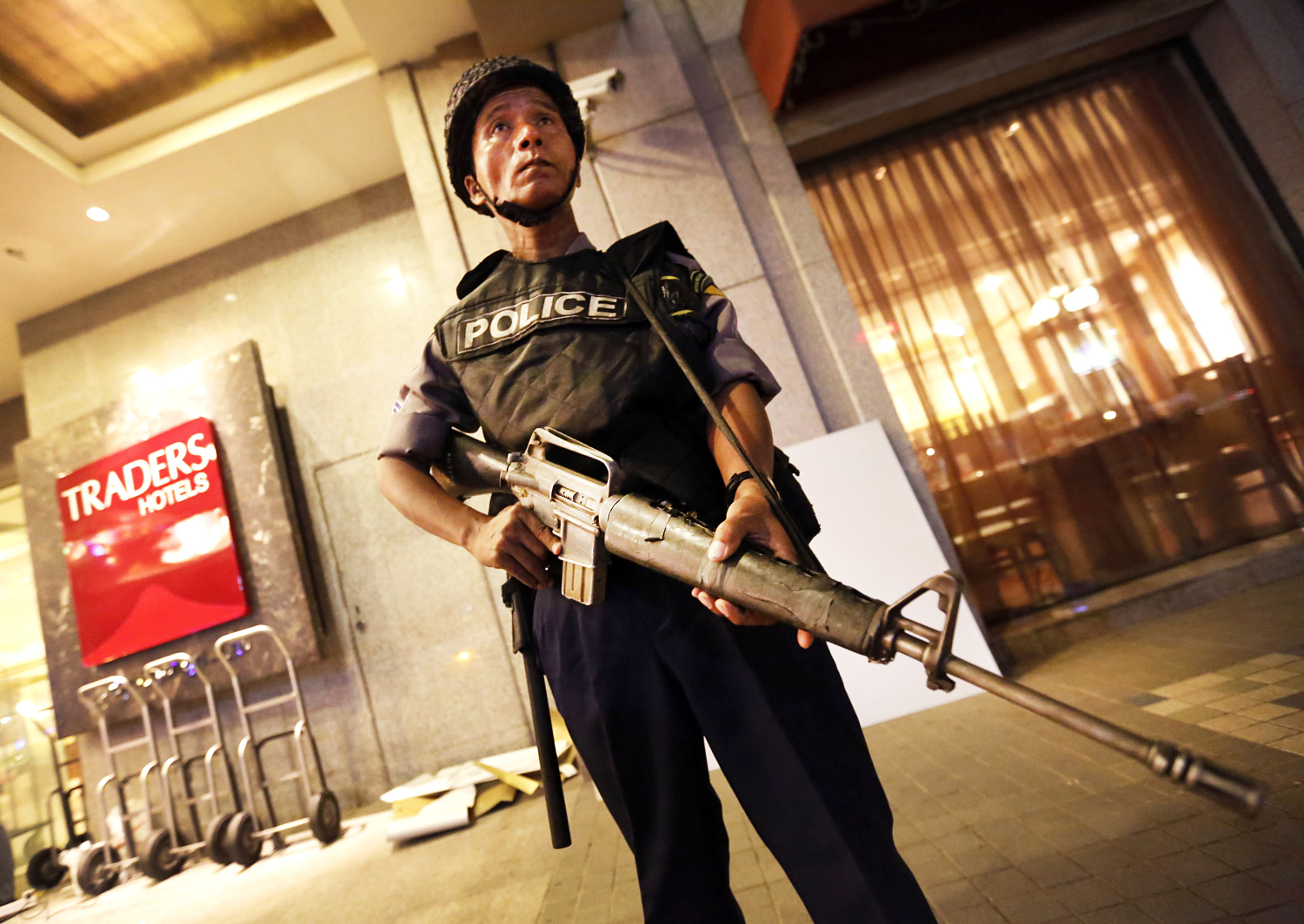 A Myanmar policeman stands guard in front of the Traders Hotel after an explosion in Yangon. Photo: Xinhua