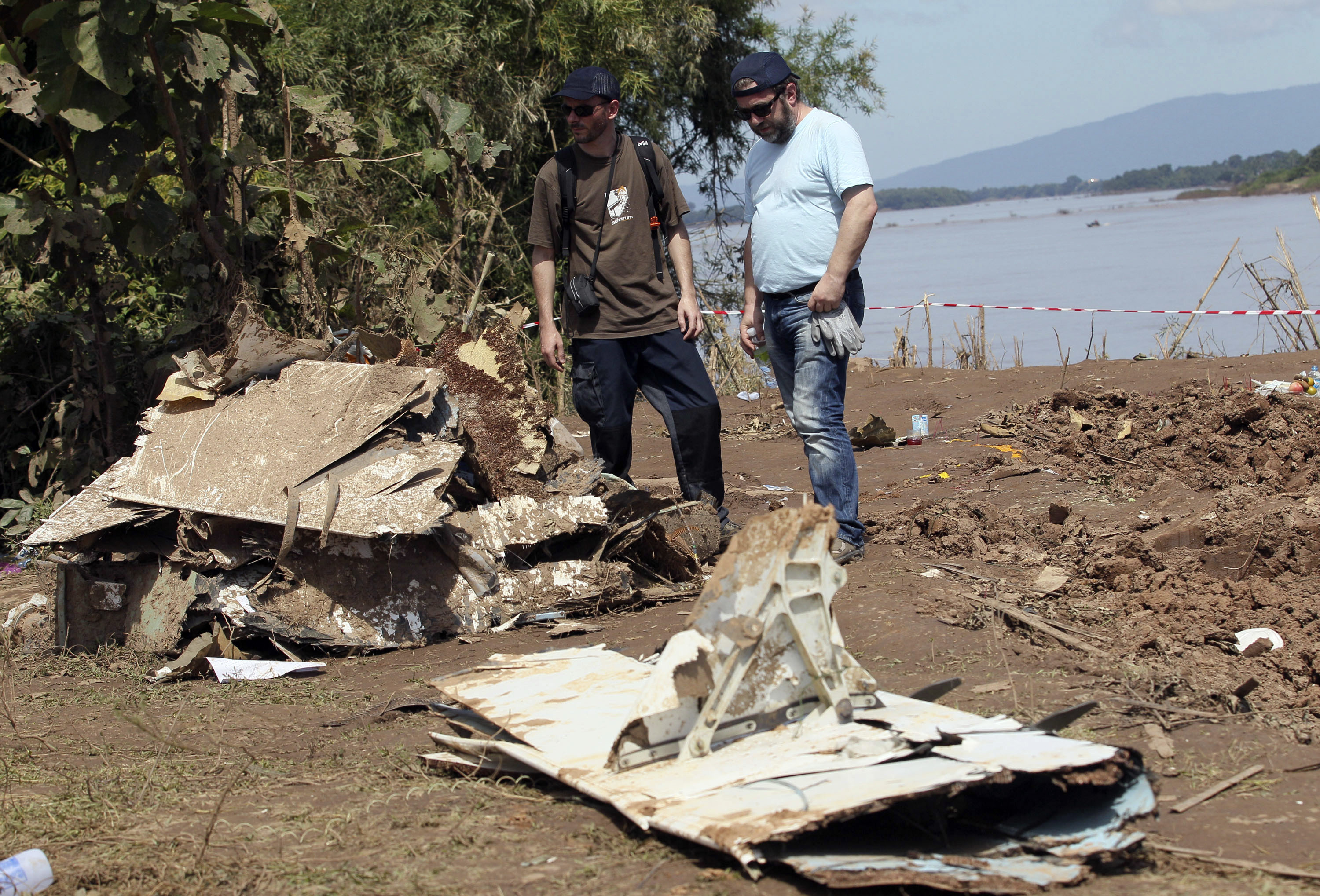 French investigators stand in front of the wreckage of a Lao Airlines plane. Photo: AP