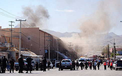 Police and rescue workers gather at Dulces Blueberry confectionery factory after an explosion in Ciudad Juarez, Mexico on Thursday. Photo: AP