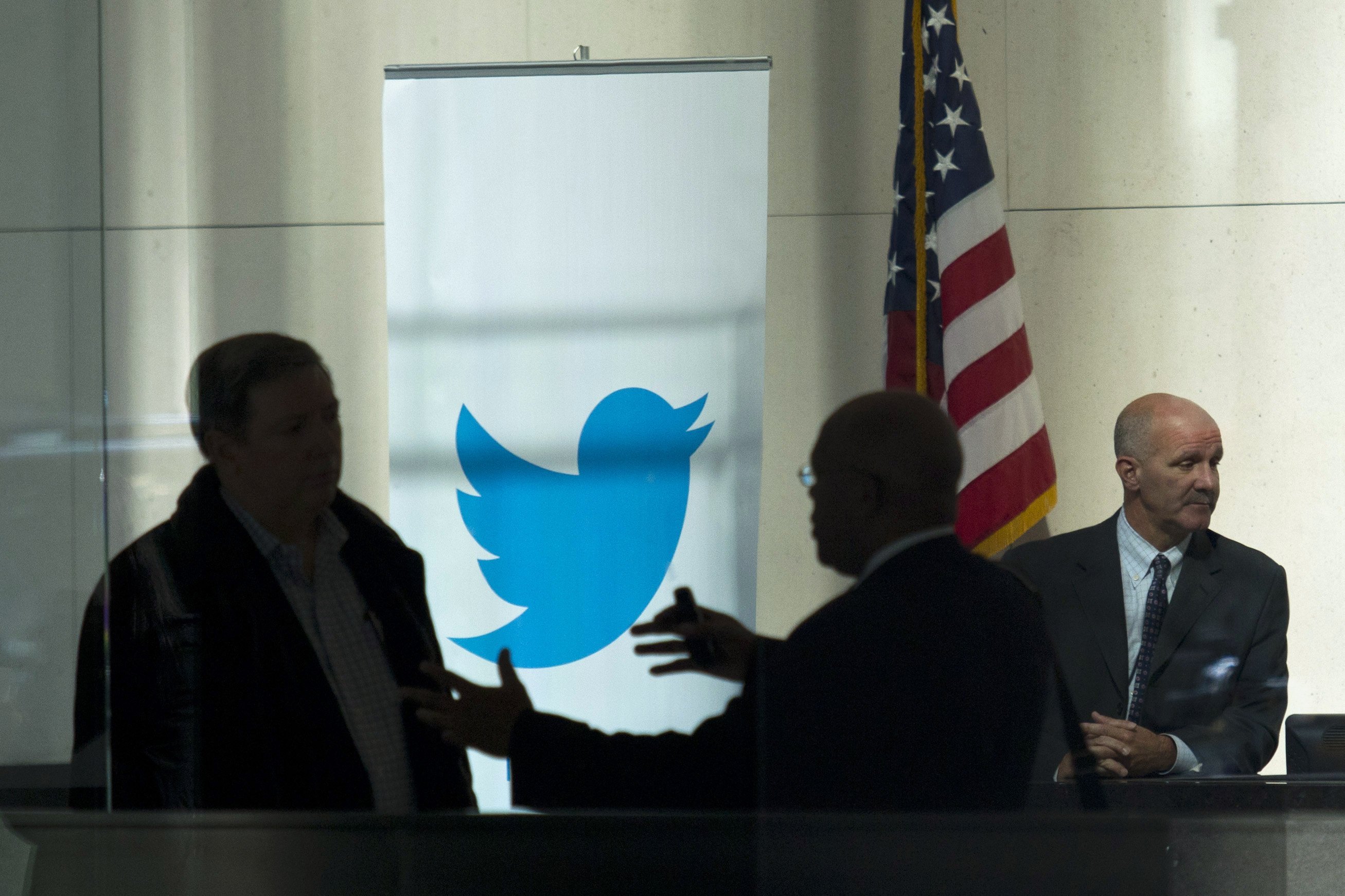 People talk inside JP Morgan headquarters near a Twitter banner, before the firm's IPO in New York. Photo: Reuters
