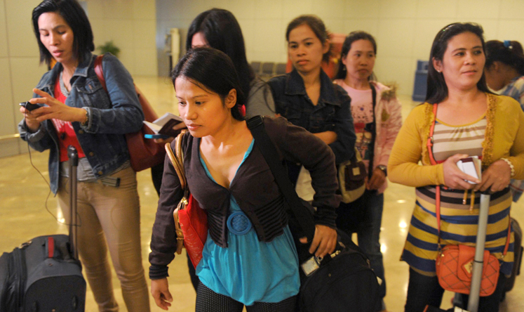 Some of the 30 repatriated Filipino workers arrive at Manila airport. Photo: AFP