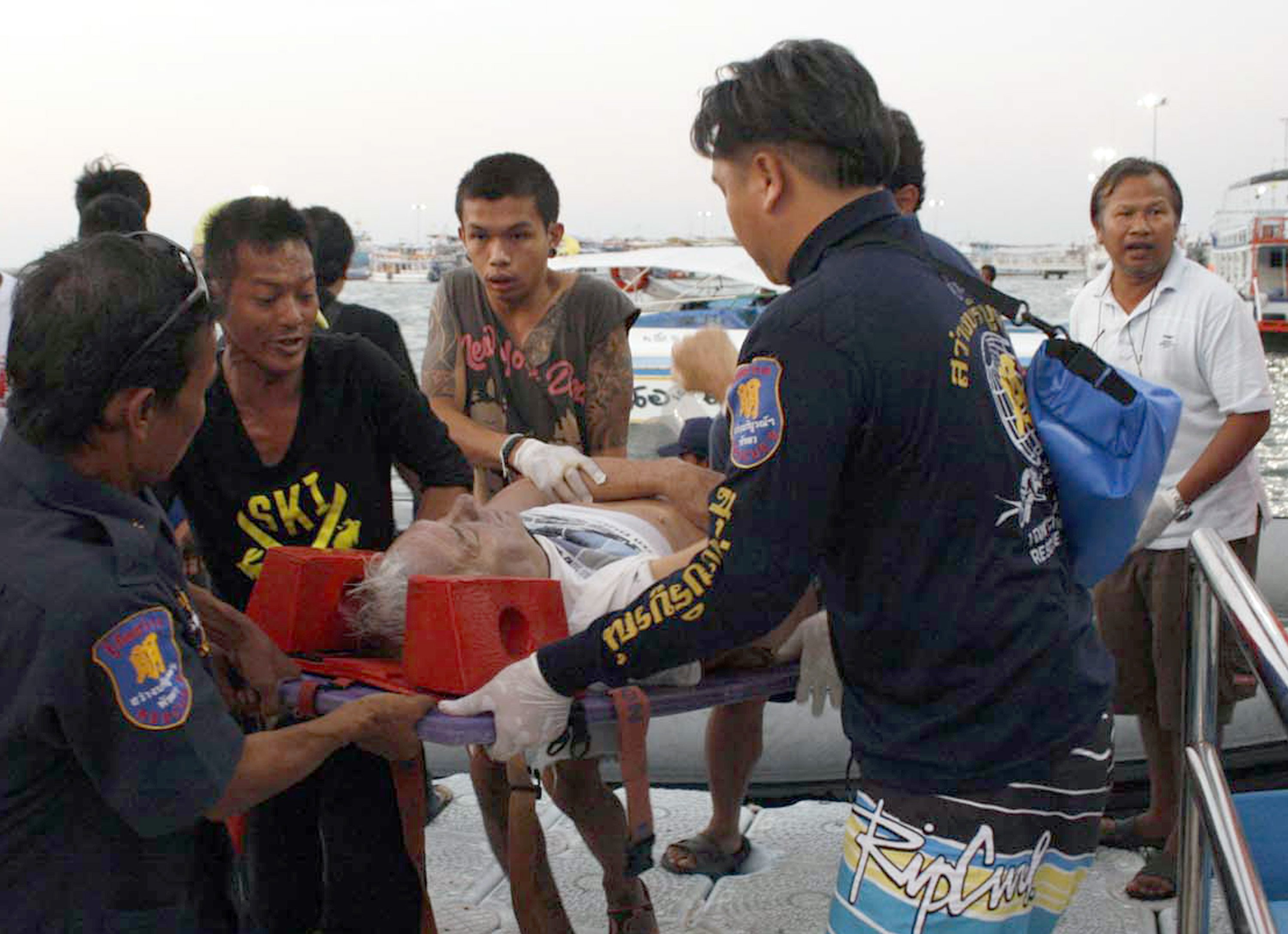 Thai rescuers carry an injured tourist on to the pier after being rescued from the sea after the boat accident in Pattaya. Photo: AP