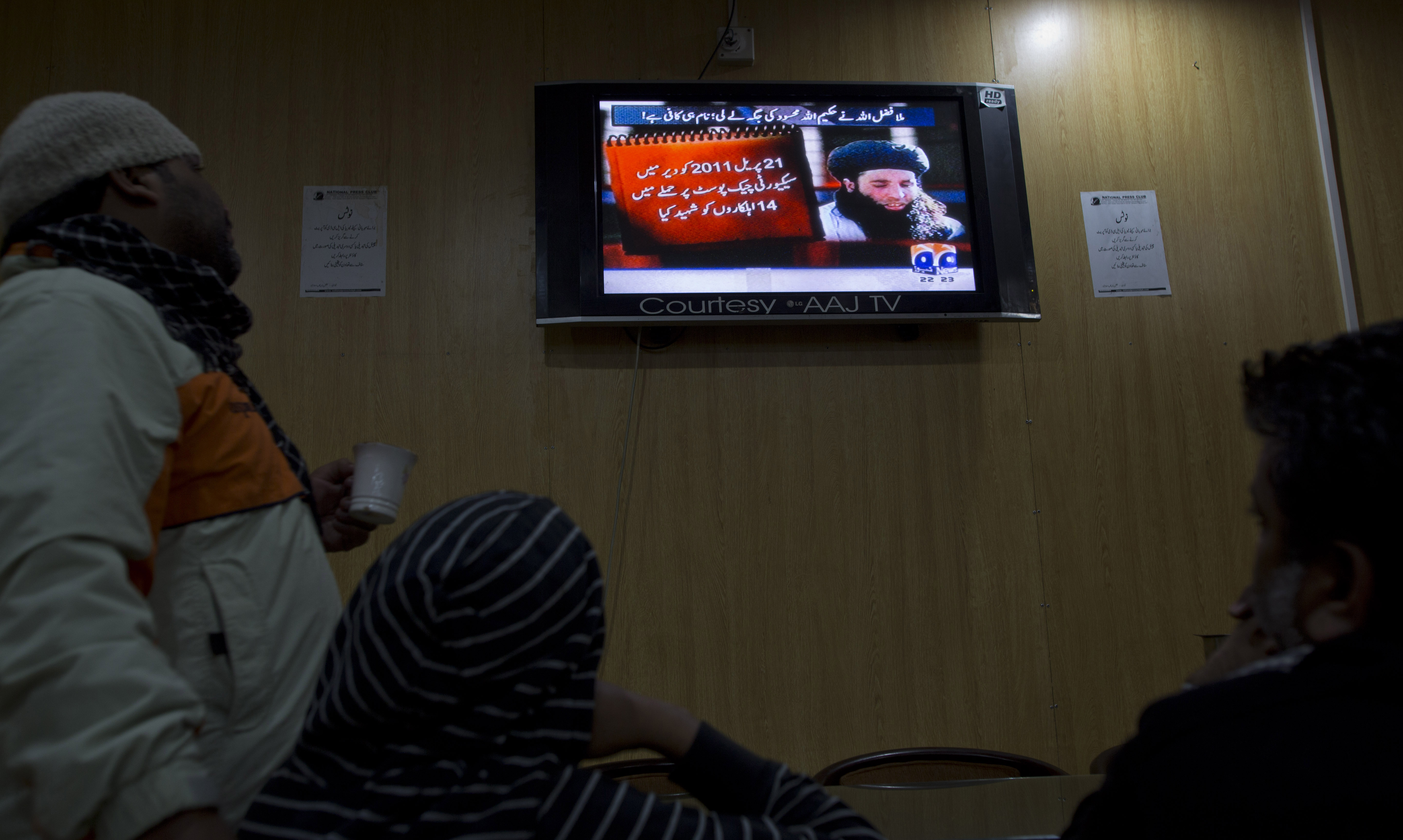 Pakistanis watch a TV news report about the new leader of the Taliban, Mullah Fazlullah, in Islamabad on Thursday. Photo: AP 