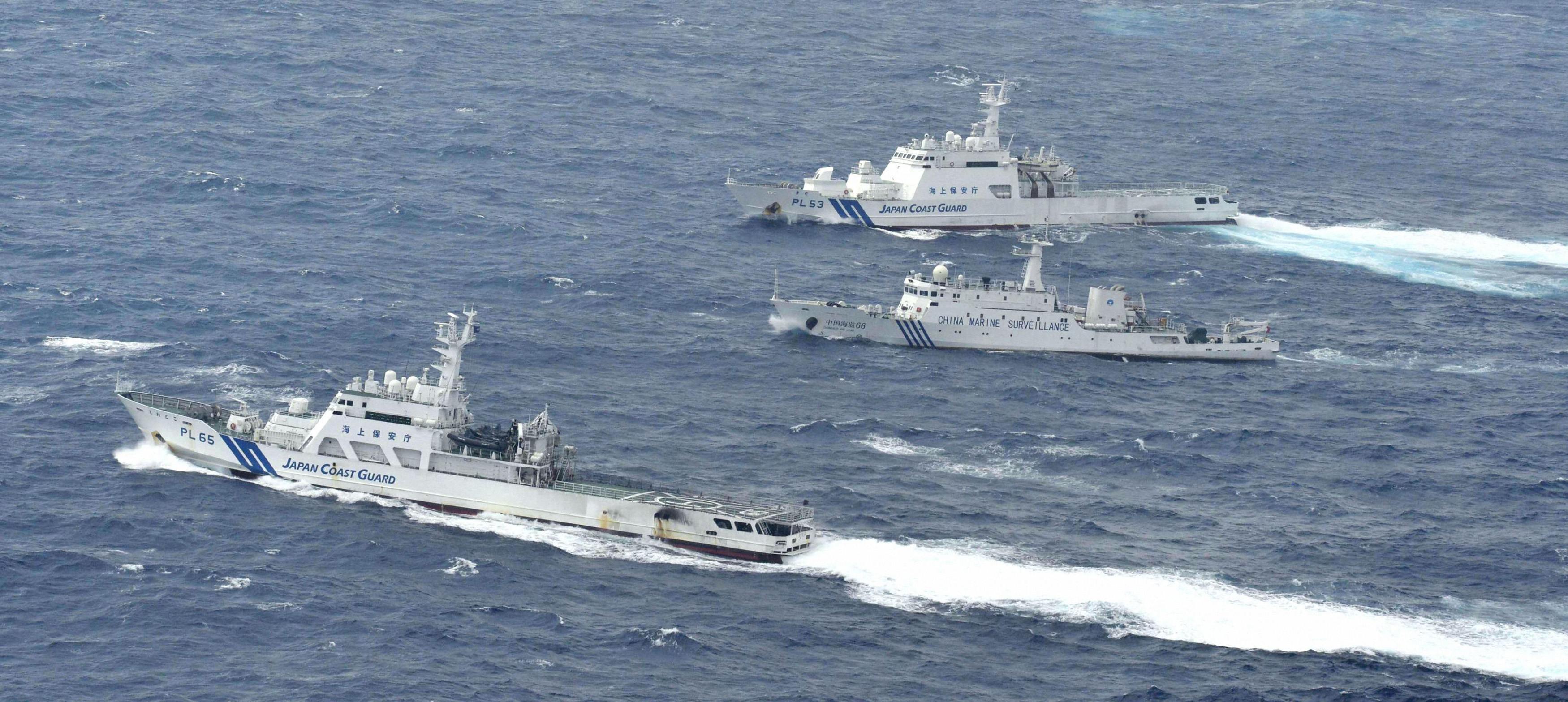 A Chinese marine surveillance ship (centre) cruises next to Japan Coast Guard patrol ships in the East China Sea. Photo: Reuters