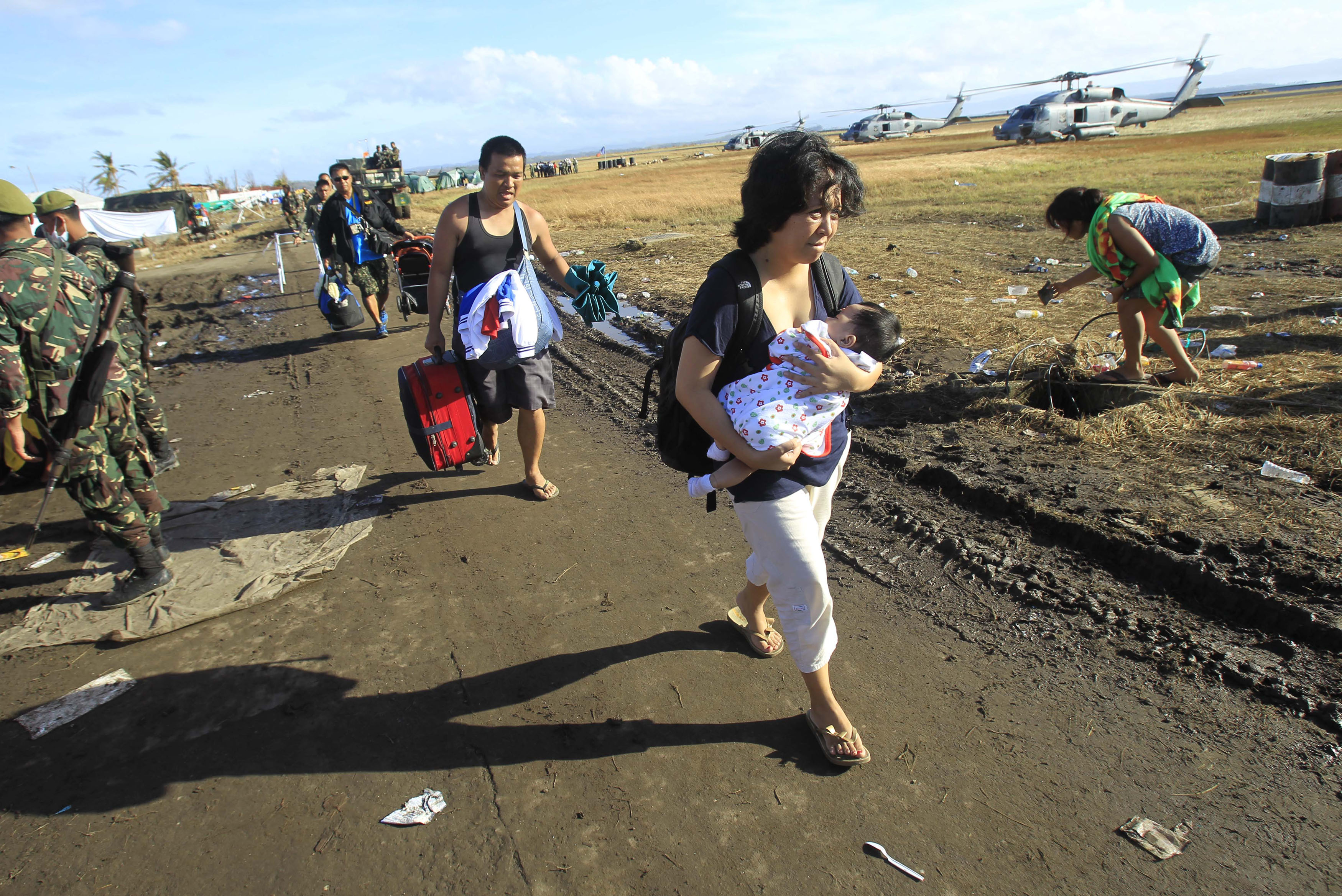 Survivors walk to an evacuation flight at Tacloban airport. Photo: AP