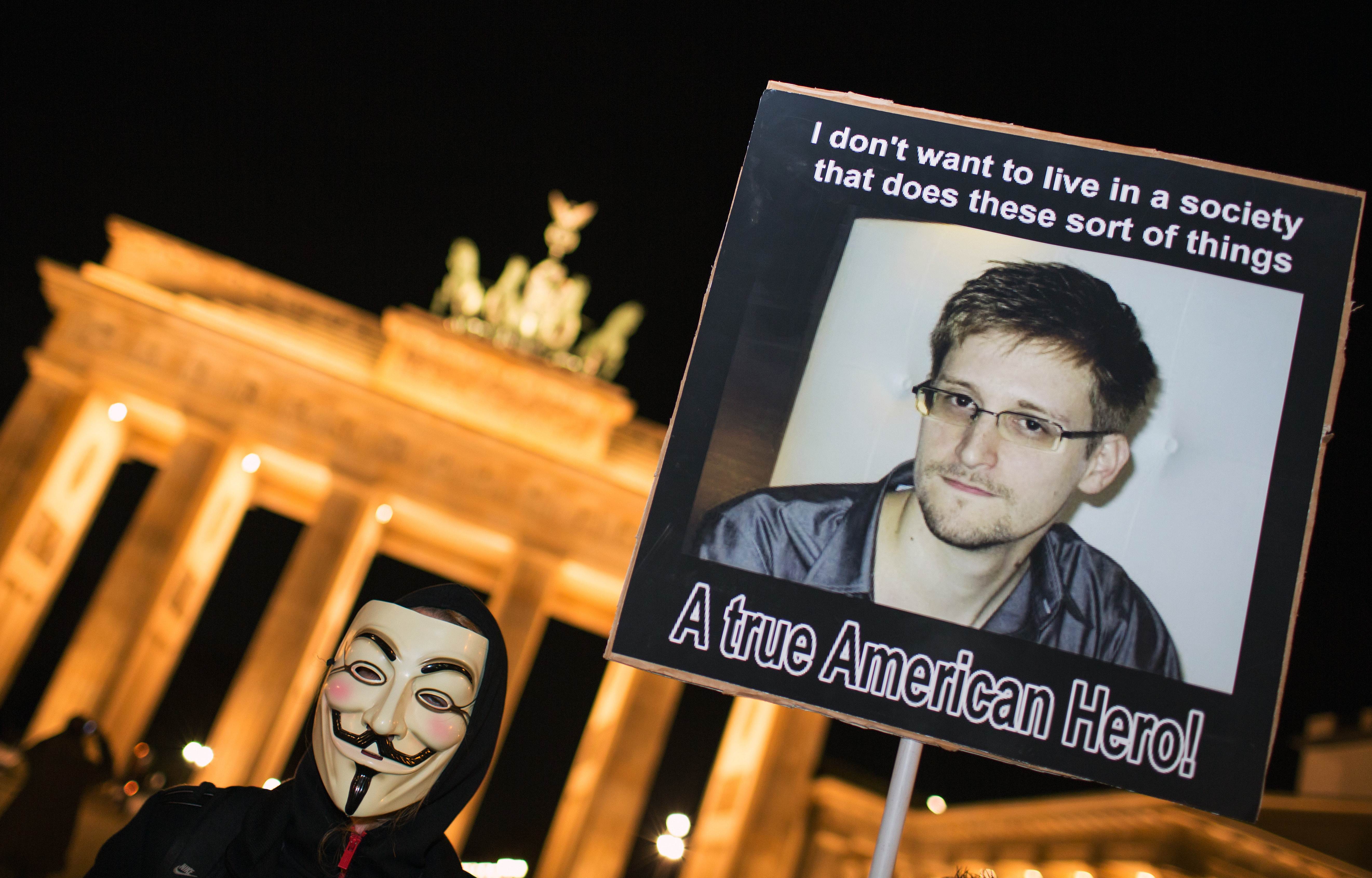 A supporter holds up a placard a rally in front of Berlin's landmark Brandenburg Gate on November 5, 2013. Photo: AFP