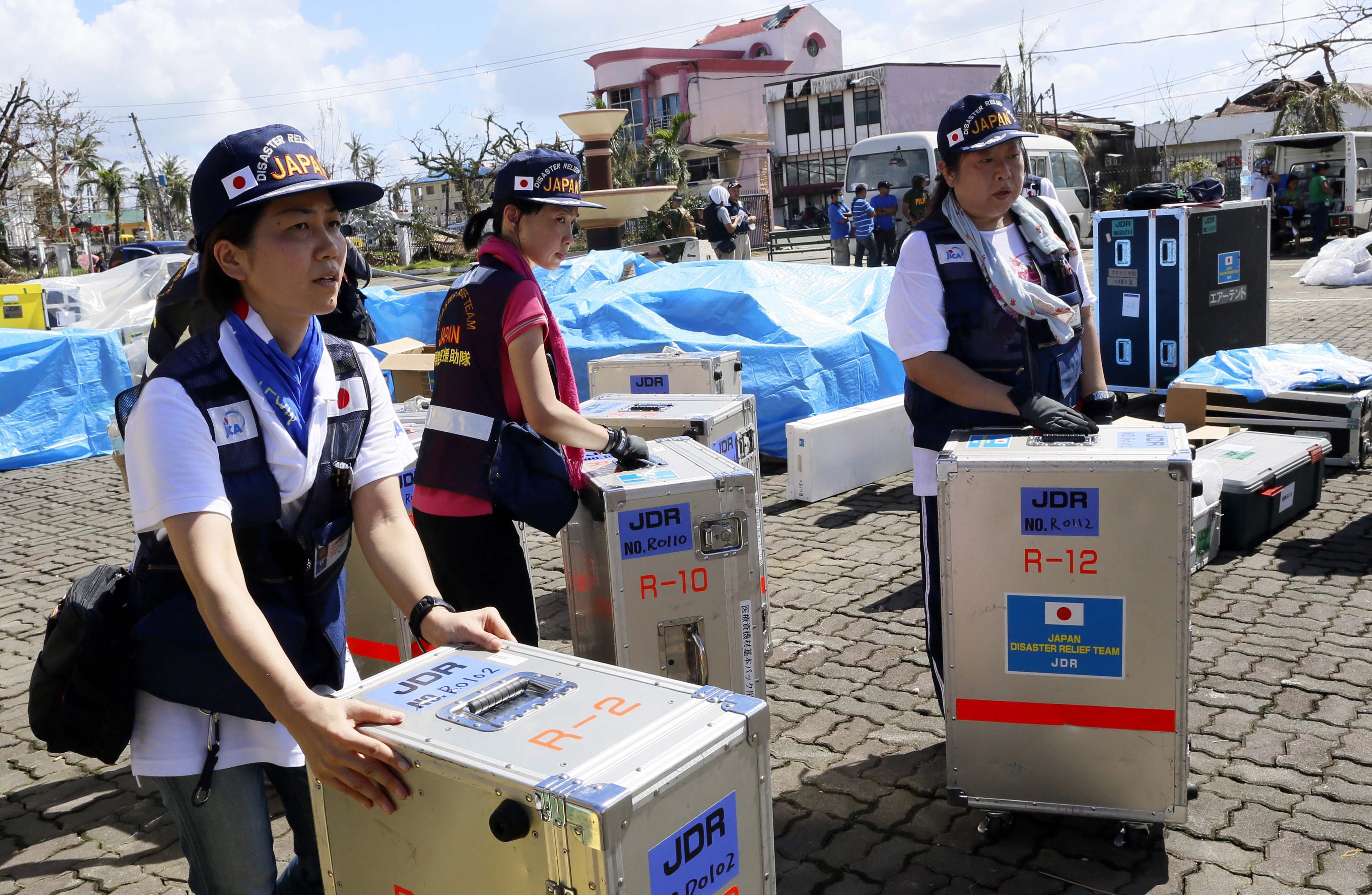 Japanese rescue team prepare their gear as they set up field hospital in the downtown of Tacloban City. Photo: EPA