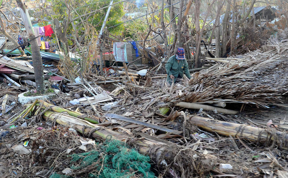 A woman salvages what is left of her belongings from her flattened house in an area devastated by Super Typhoon Haiyan. Photo: AFP