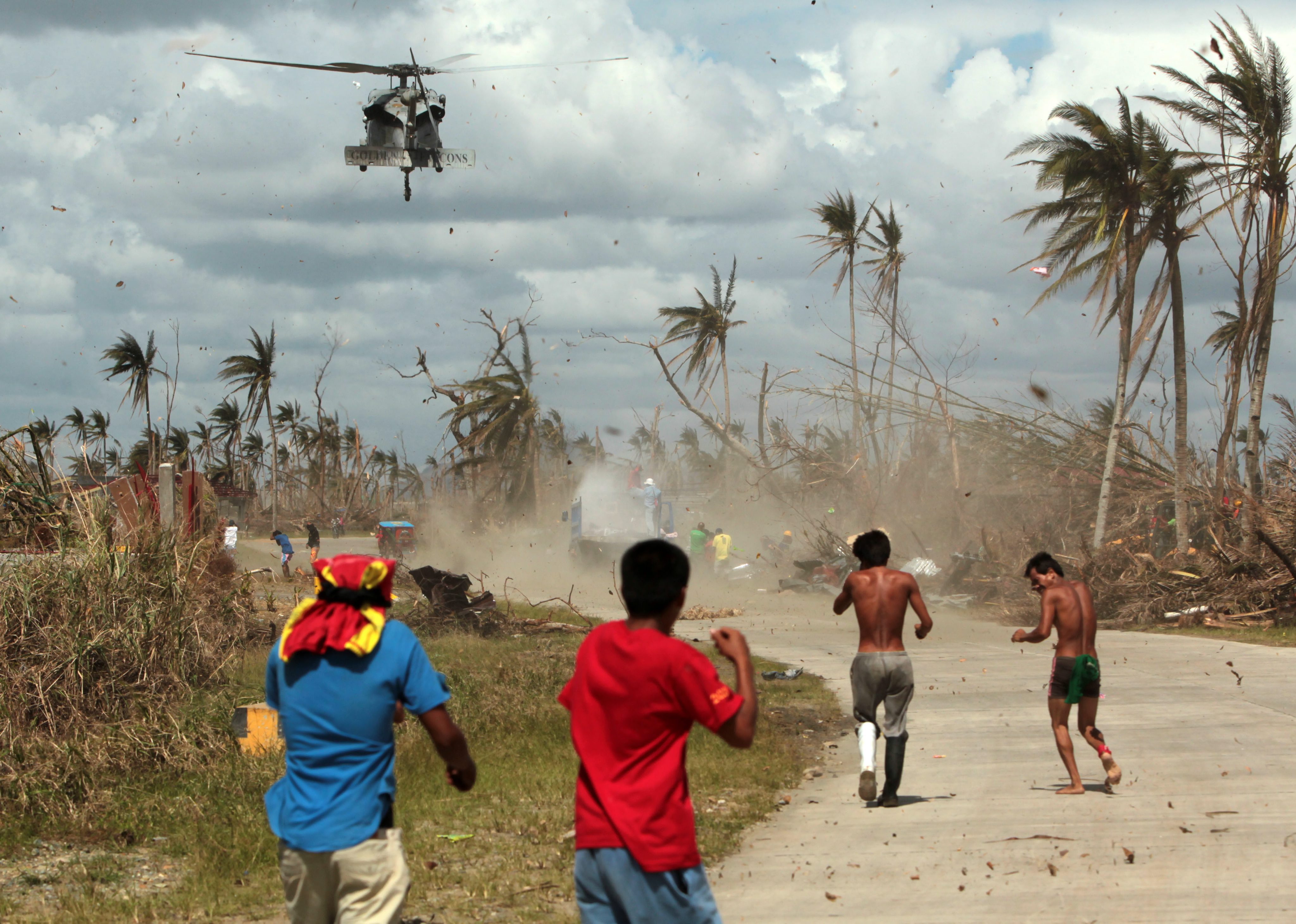 Filipino typhoon victims rush to get relief goods from a US Navy Sea Hawk helicopter in the typhoon devastated town of Palo, Leyte island province, Philippines. Photo: EPA