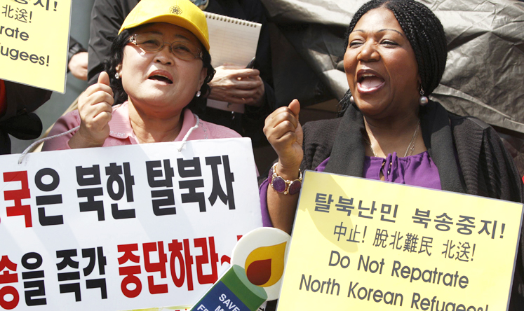 Singer Liz Mitchell and a North Korean defector chant slogans in a rally demanding China to stop repatriating North Korean refugees. Photo: Reuters