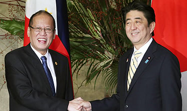 Japanese Prime Minister Shinzo Abe (right) shakes hands with Philippine President Benigno Aquino at the start of their working lunch at the prime minister's official residence in Tokyo on Friday. Photo: Reuters