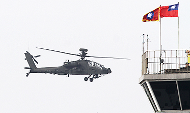 Taiwan's AH-64E Apache attack helicopter purchased from the US flies near national flags during a commissioning ceremony in Tainan, Taiwan, on Friday. Photo: AP 