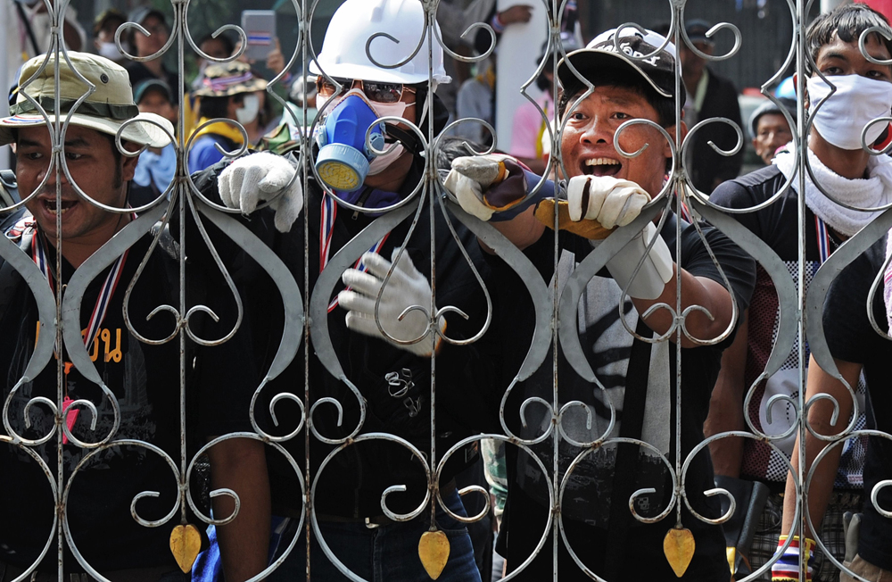 Thai anti-government protesters shout at police from outside the besieged Government House compound during an ongoing protest in Bangkok on Thursday. Photo: AFP
