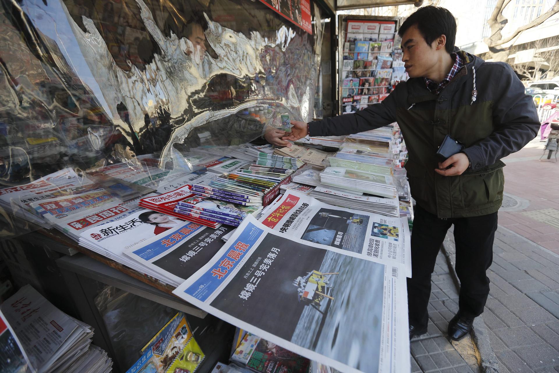 The lunar rover's landing was splashed across the front pages of mainland papers as seen from this newsstand in Beijing. Photo: EPA