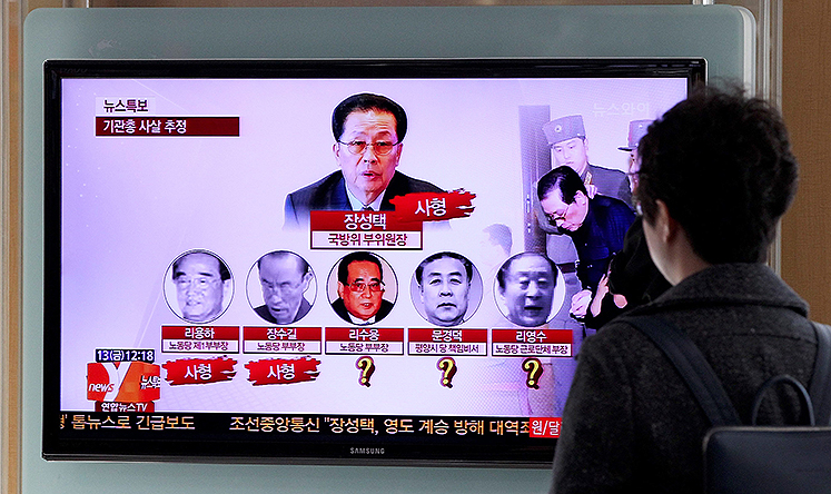 A South Korean commuter watches a news report on the demise of North Korean politician Jang Song-Thaek at a train station in Seoul. Photo: EPA
