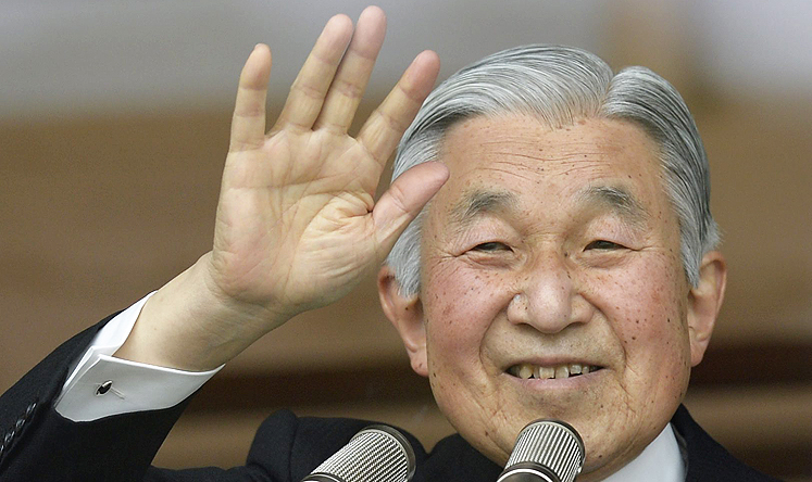 Japanese Emperor Akihito waves to thousands of well-wishers through a bullet-proof glass on his 80th birthday at the Imperial Palace in Tokyo, Japan, on Monday. Photo: EPA