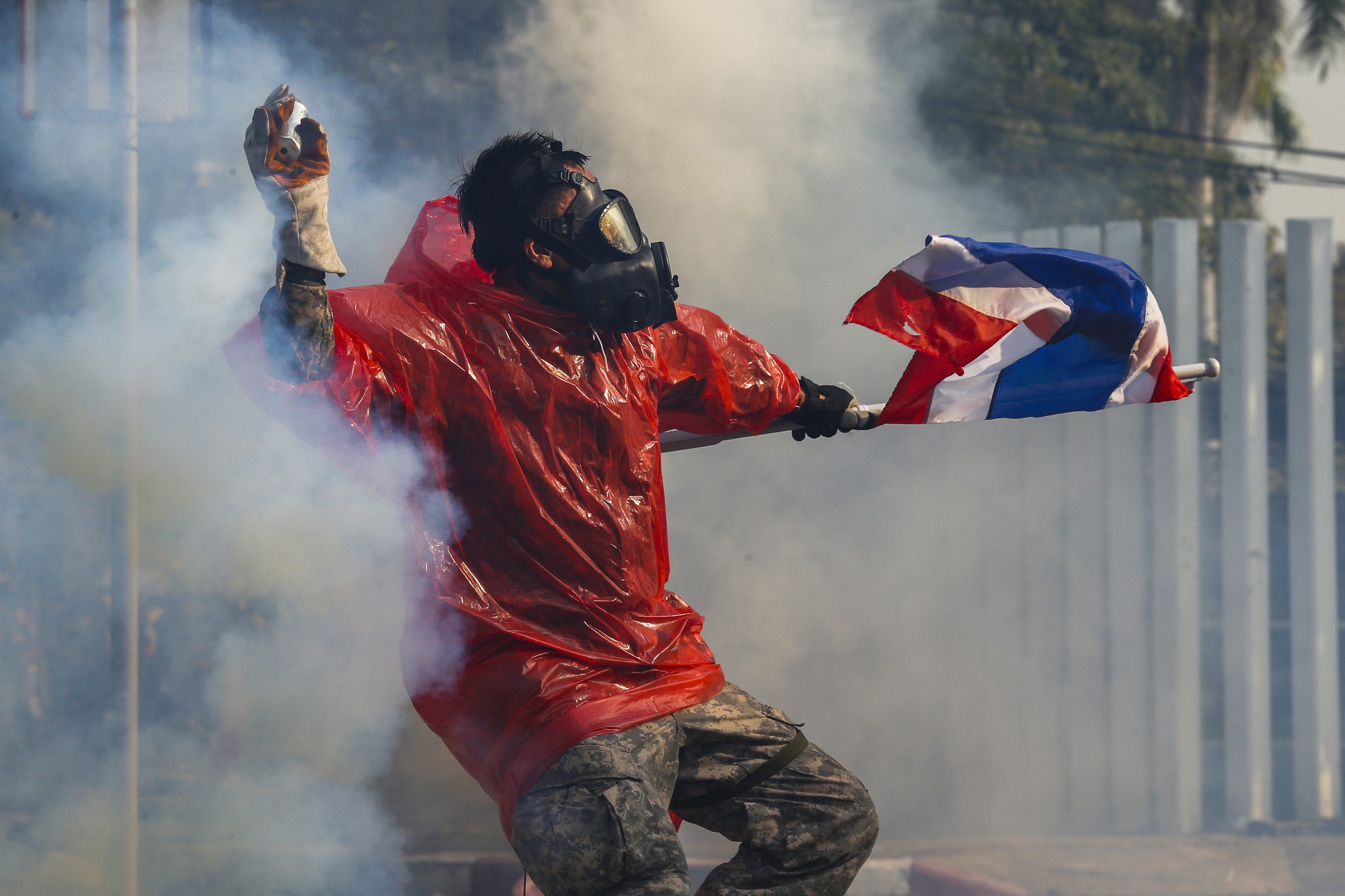 Anti-government protesters throw rocks and tear gas canisters at police in Bangkok as protests take a violent turn ahead of February's election. Photo: Reuters